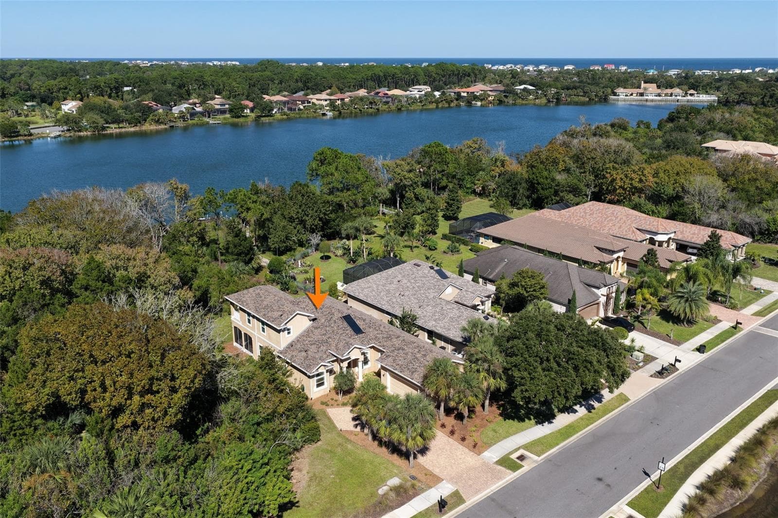 A sweeping aerial view showcases Emerald Lake behind the property, surrounded by lush natural greenery. - 25 EMERALD LAKE CT, PALM COAST