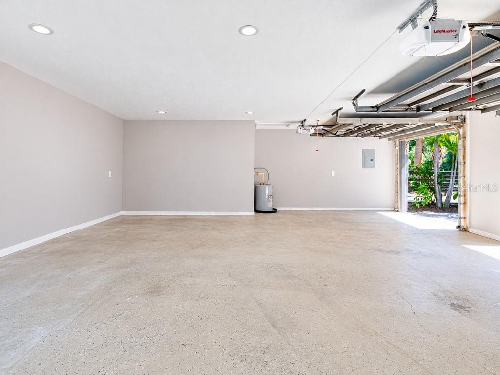 Another view of the extended three-car garage, showcasing the impressive open floor area and additional space for storage, a workshop or car enthusiast needs. - 403 LONGBOW TRL, OSPREY