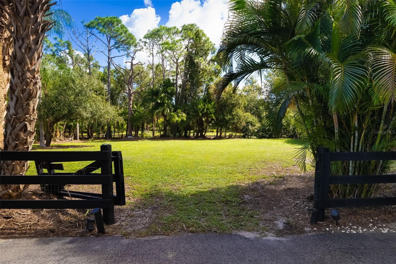 Another view of the property's expansive open acreage, offering flexibility for vehicle storage, recreational space, horses or a future accessory building, subject to applicable approvals. - 403 LONGBOW TRL, OSPREY