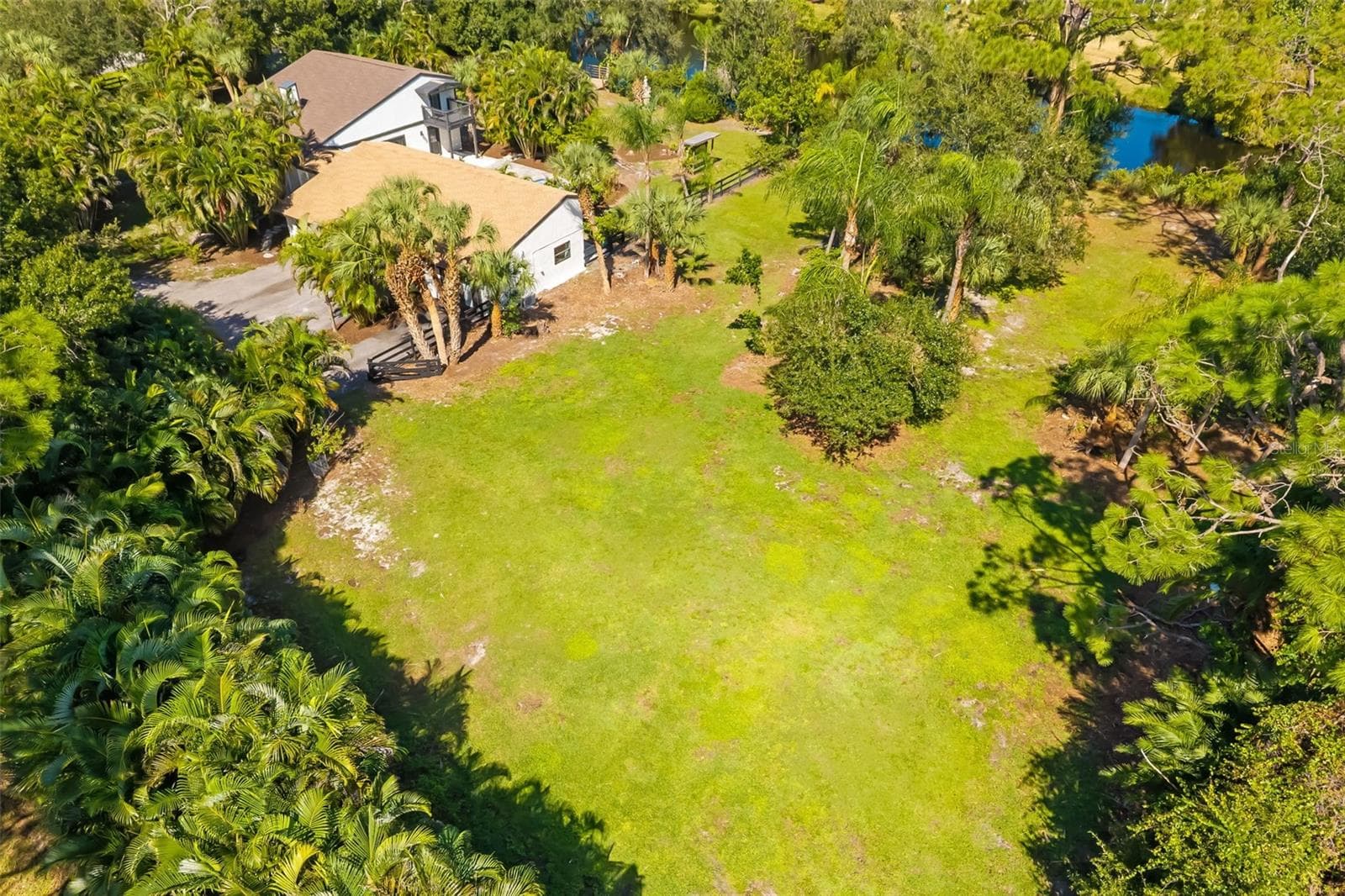 Aerial view highlighting the generous open area of this two-acre property—an exceptional opportunity to explore additional garage, workshop, recreational or equestrian uses, subject to applicable approvals. - 403 LONGBOW TRL, OSPREY