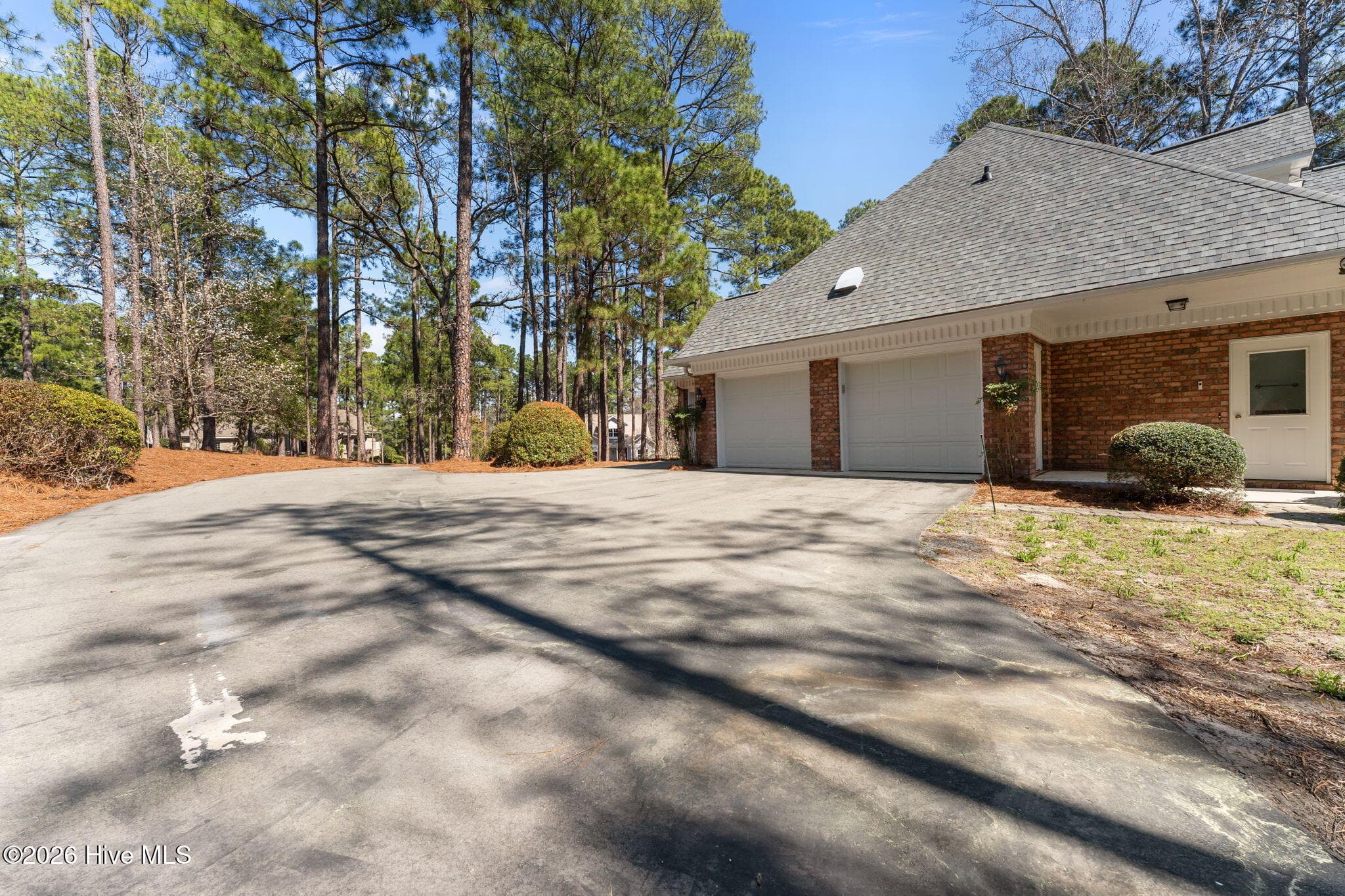 View of the far corner of the driveway showing 2/3 garages. - 22 Lochmere Drive, Pinehurst, NC 28374