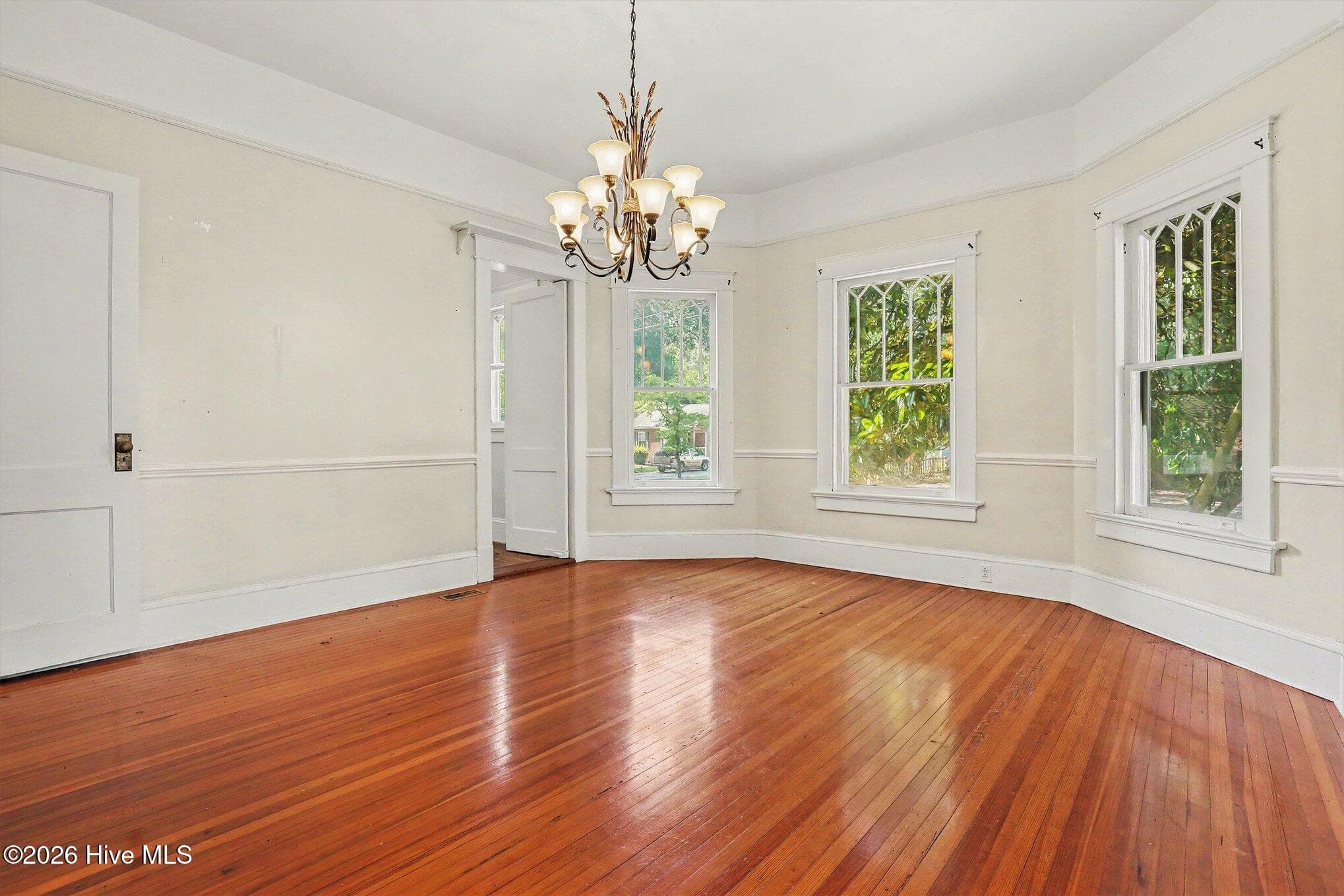 Dining room with hardwoods, bayed windows, heavy crown and chair moldings - 202 N Green Street, Selma, NC 27576