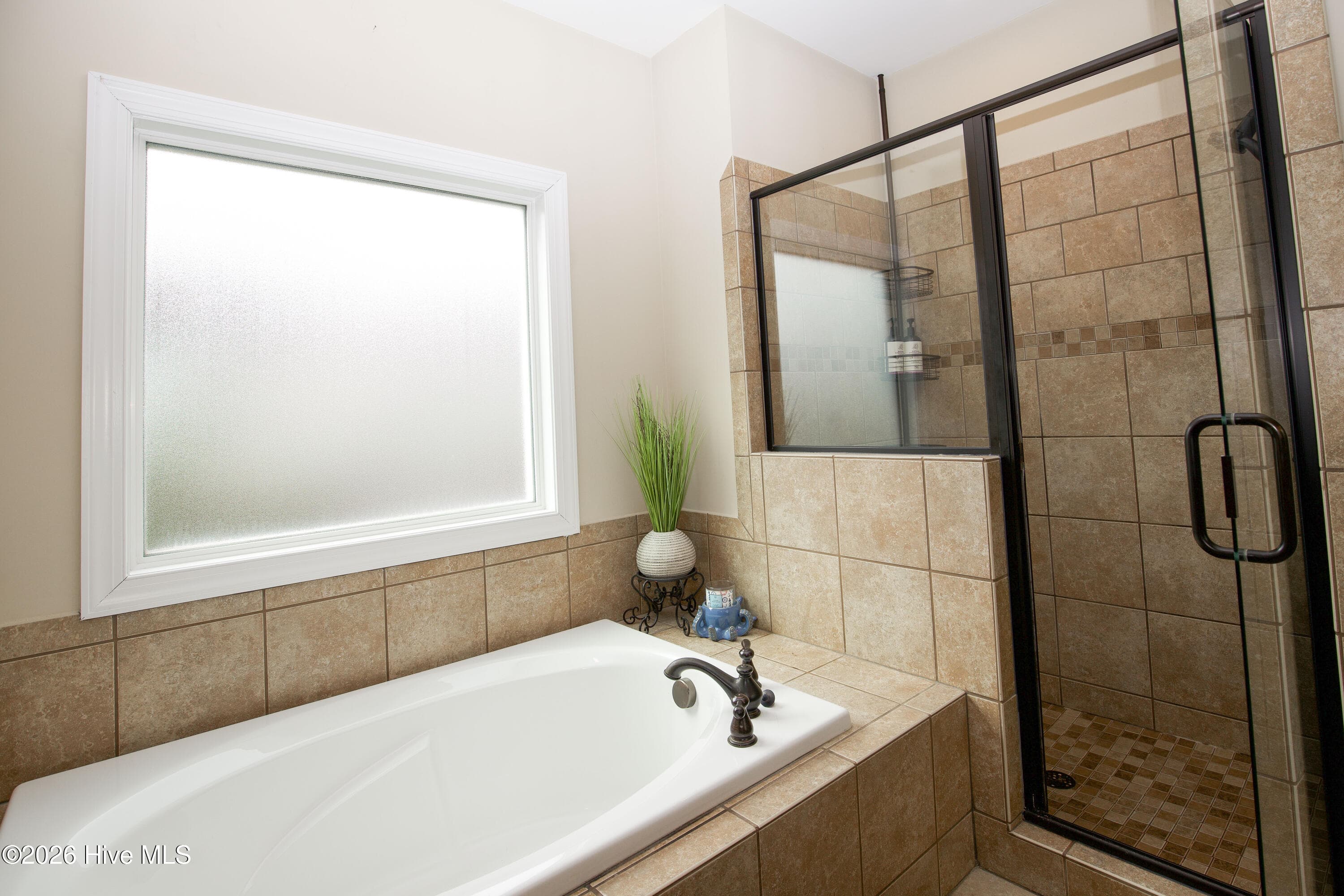 Primary bathroom with a soaking tub and a glass-enclosed tiled shower. - 899 Seagull Drive, Vass, NC 28394, Vass