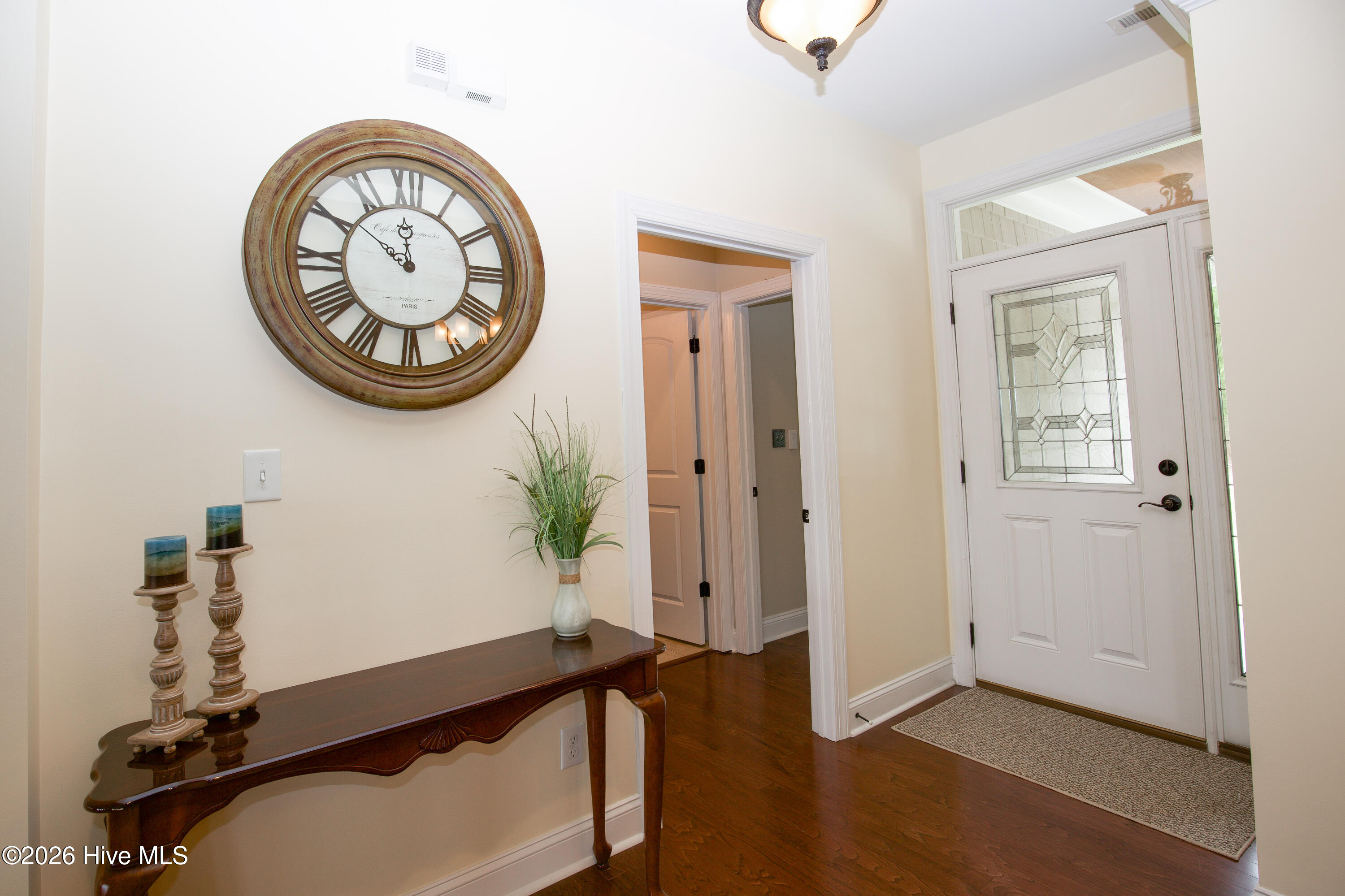 Foyer with a leaded-glass front door, sidelight, and transom, opening to the main living spaces. - 899 Seagull Drive, Vass, NC 28394, Vass