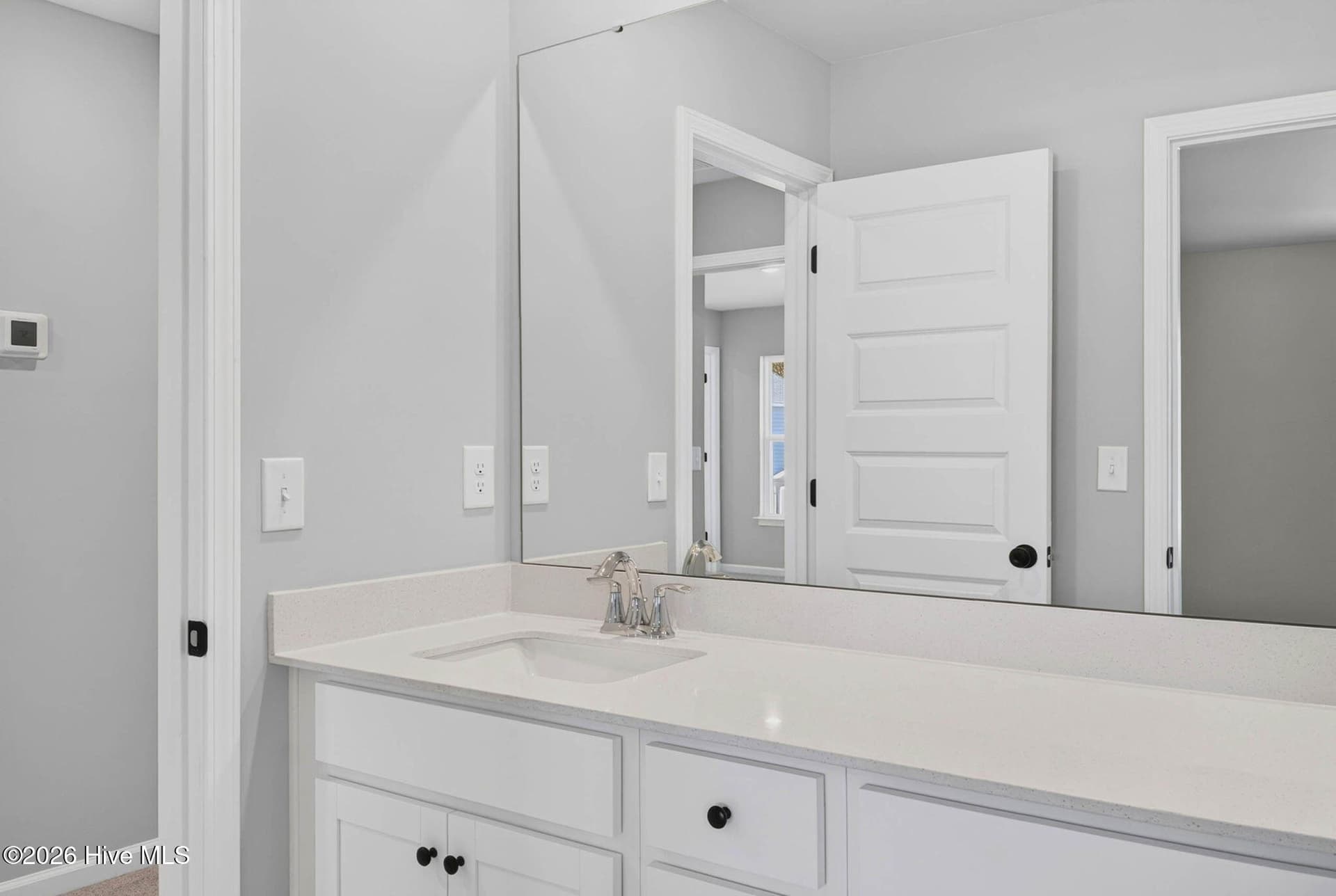Guest suite bathroom featuring a dual-sink vanity, white cabinetry, and modern fixtures. - 3447 Sandhill Crane Drive SW, Ocean Isle Beach, NC 28469
