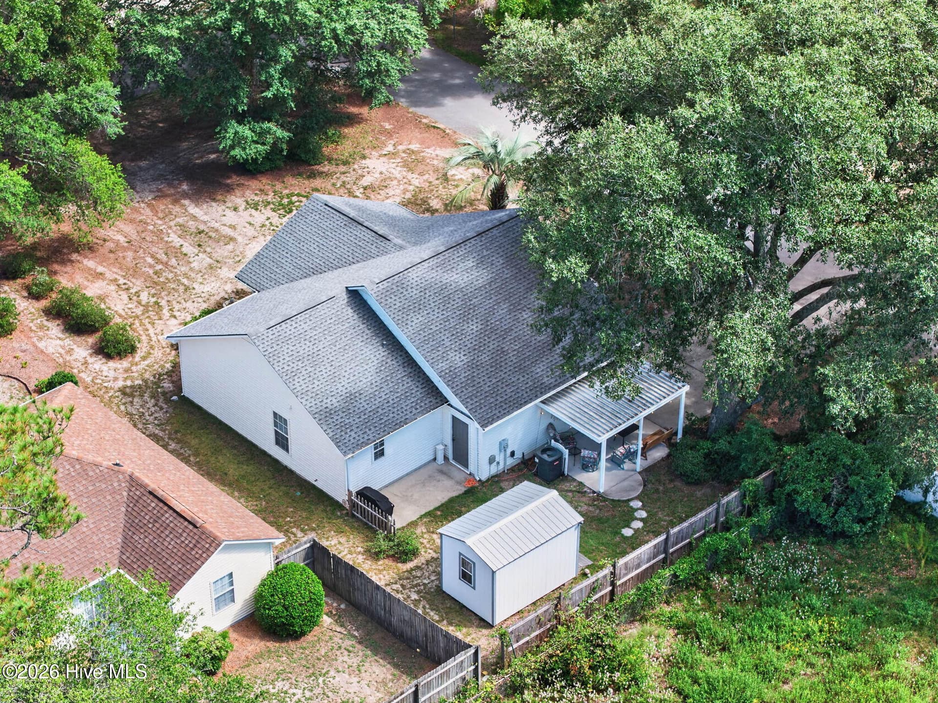Elevated view showcases the home, attached garage, outdoor living areas, and backyard storage shed. - 1650 Frink Street SW, Ocean Isle Beach, NC 28469