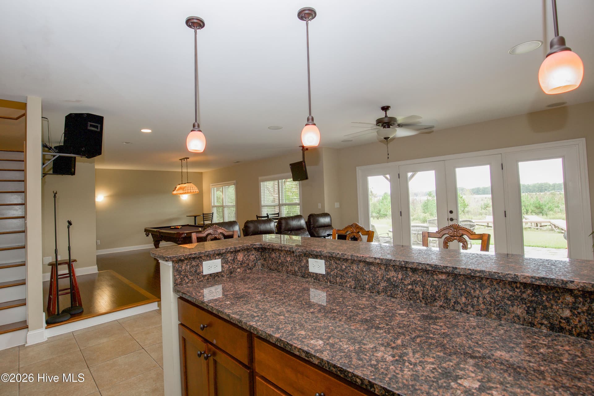View from the wet bar across the lower level toward the French doors and recreation room. A motorized stairlift provides an additional option for accessing the finished lower level and conveys with the home. - 899 Seagull Drive, Vass, NC 28394