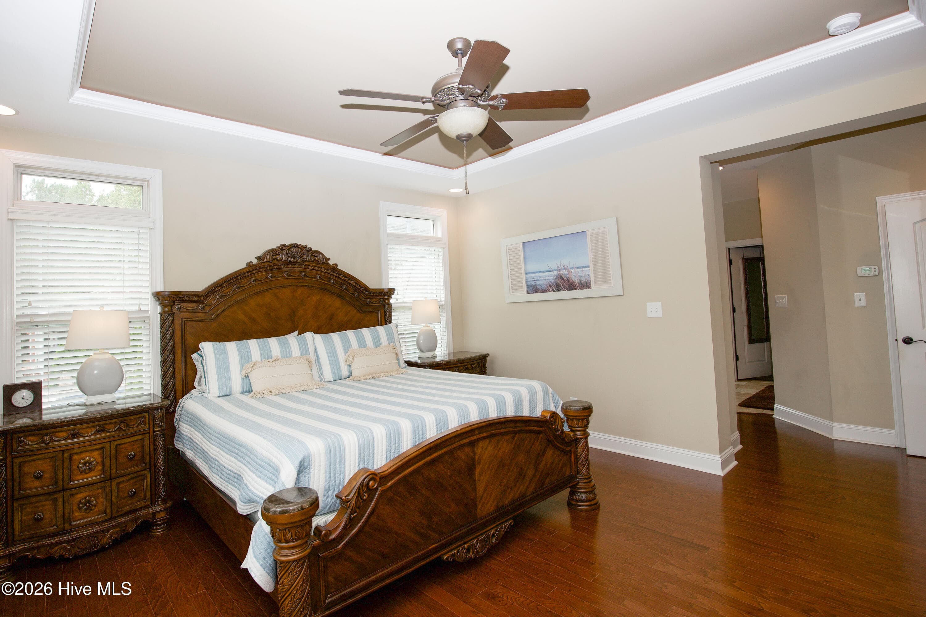 Primary bedroom with windows on two walls and a tray ceiling. - 899 Seagull Drive, Vass, NC 28394, Vass