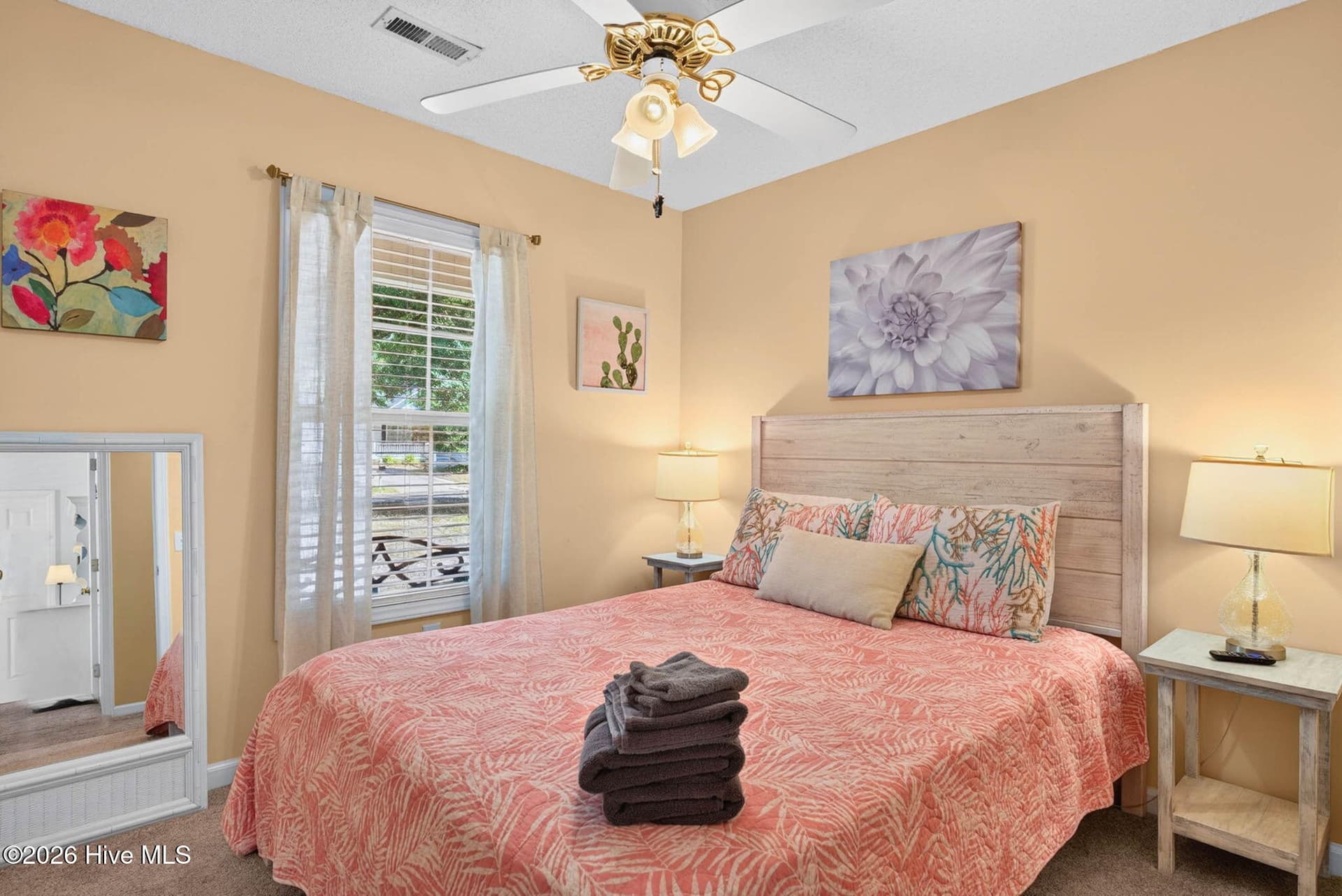 Bright guest bedroom with ceiling fan and natural light, offering comfortable accommodations for family or vacation guests. - 1650 Frink Street SW, Ocean Isle Beach, NC 28469
