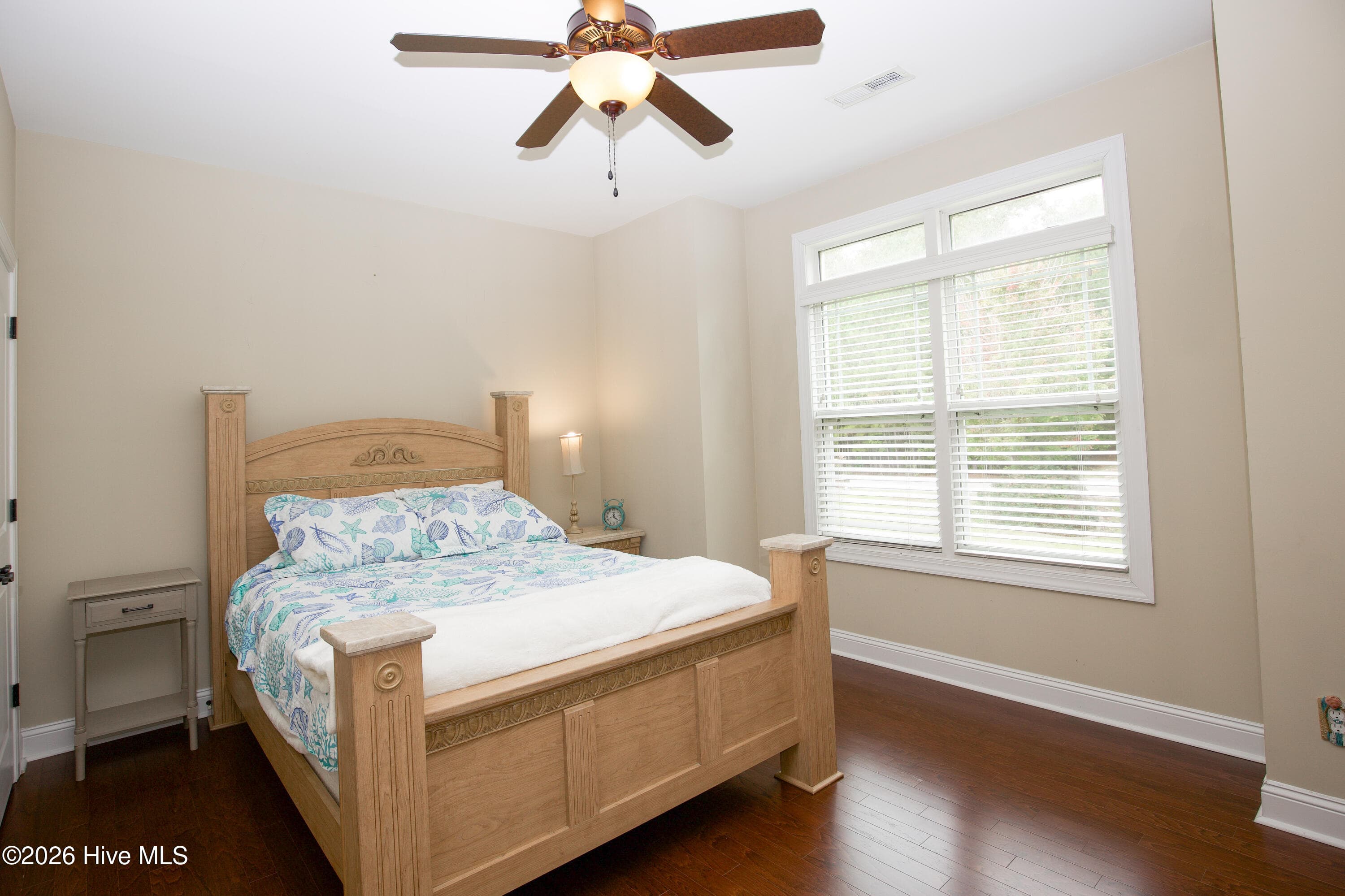 Main-level second bedroom with a ceiling fan and natural light. - 899 Seagull Drive, Vass, NC 28394, Vass
