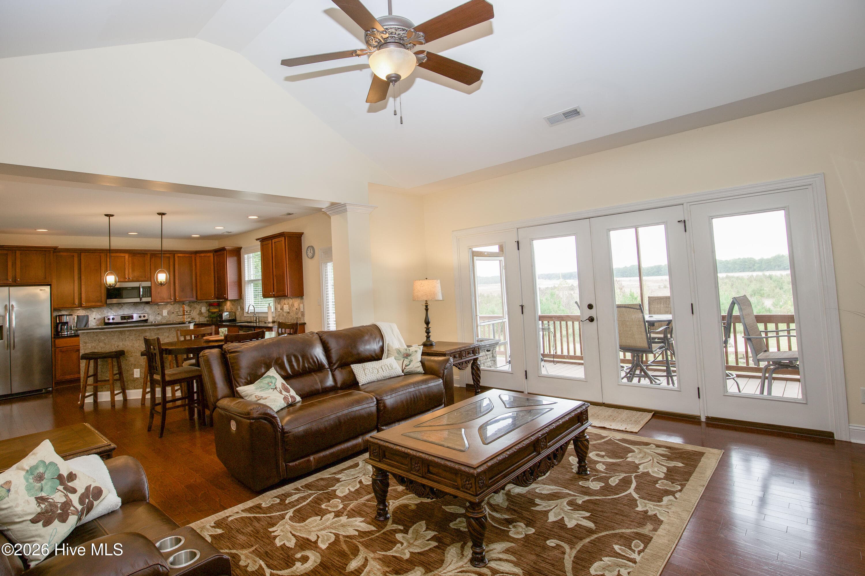 Living room open to the kitchen and breakfast area, with natural light from the covered back porch doors. - 899 Seagull Drive, Vass, NC 28394, Vass