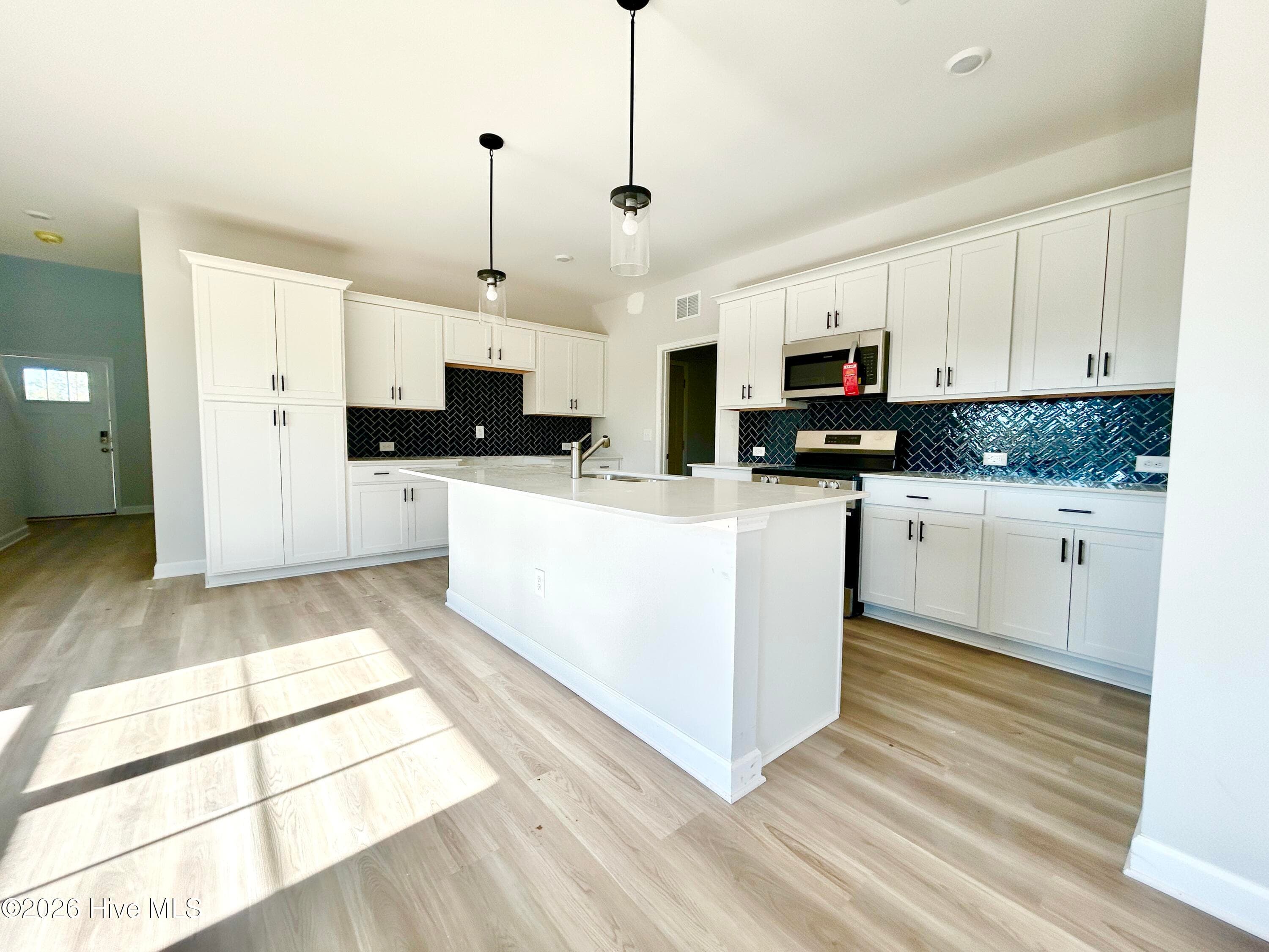 Stunning Kitchen includes Quartz Countertops, Stainless Appliances, Tile Backsplash, Beautiful Lighting fixtures and an abundance of Cabinets. - 4208 Workman Loop 94, Leland, NC 28451