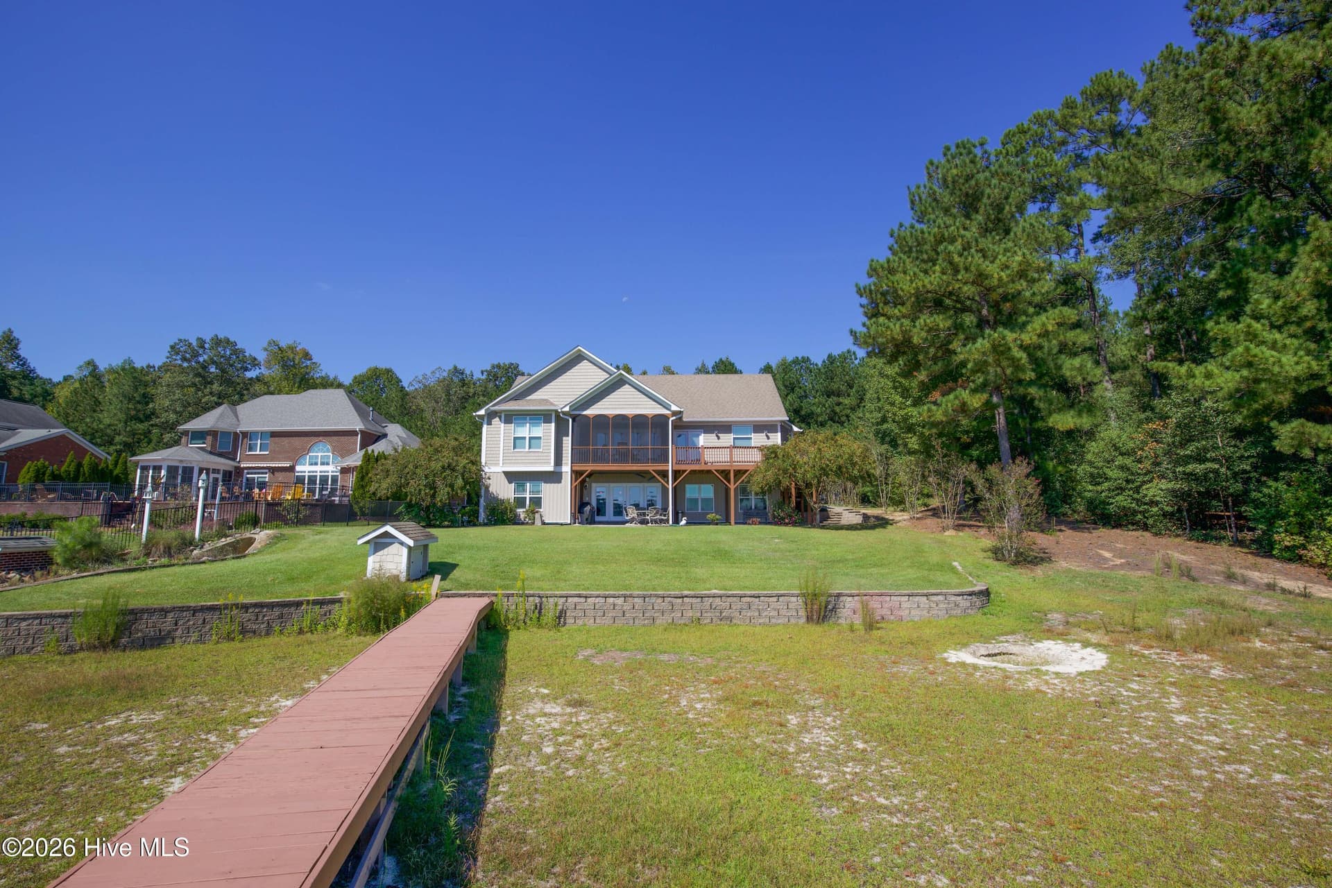 Rear of the home with the retaining wall and dock walkway. - 899 Seagull Drive, Vass, NC 28394