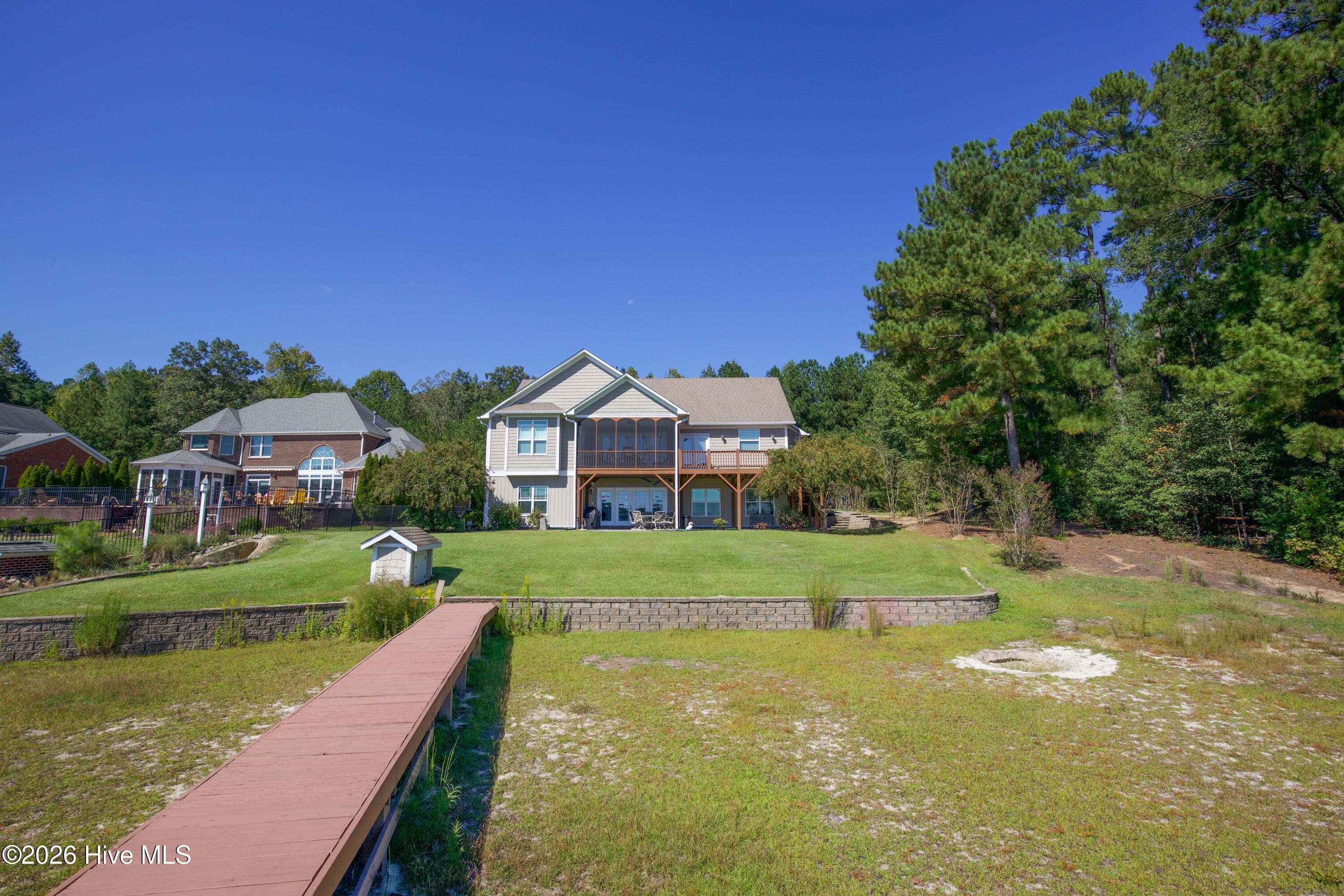 Rear of the home with the retaining wall and dock walkway. - 899 Seagull Drive, Vass, NC 28394, Vass