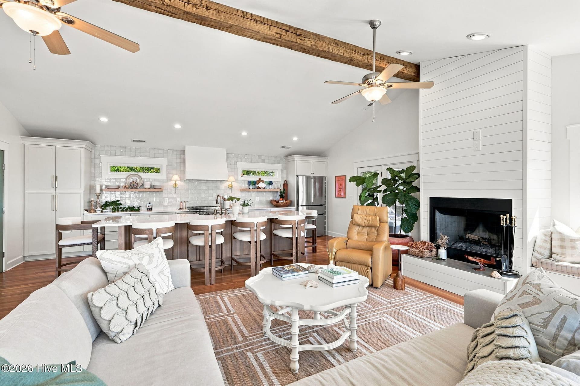 Cozy wood-burning fireplace with custom shiplap surround and rustic wood beam adds warmth and character to the living space. - 103 Georgia Street, Emerald Isle, NC 28594