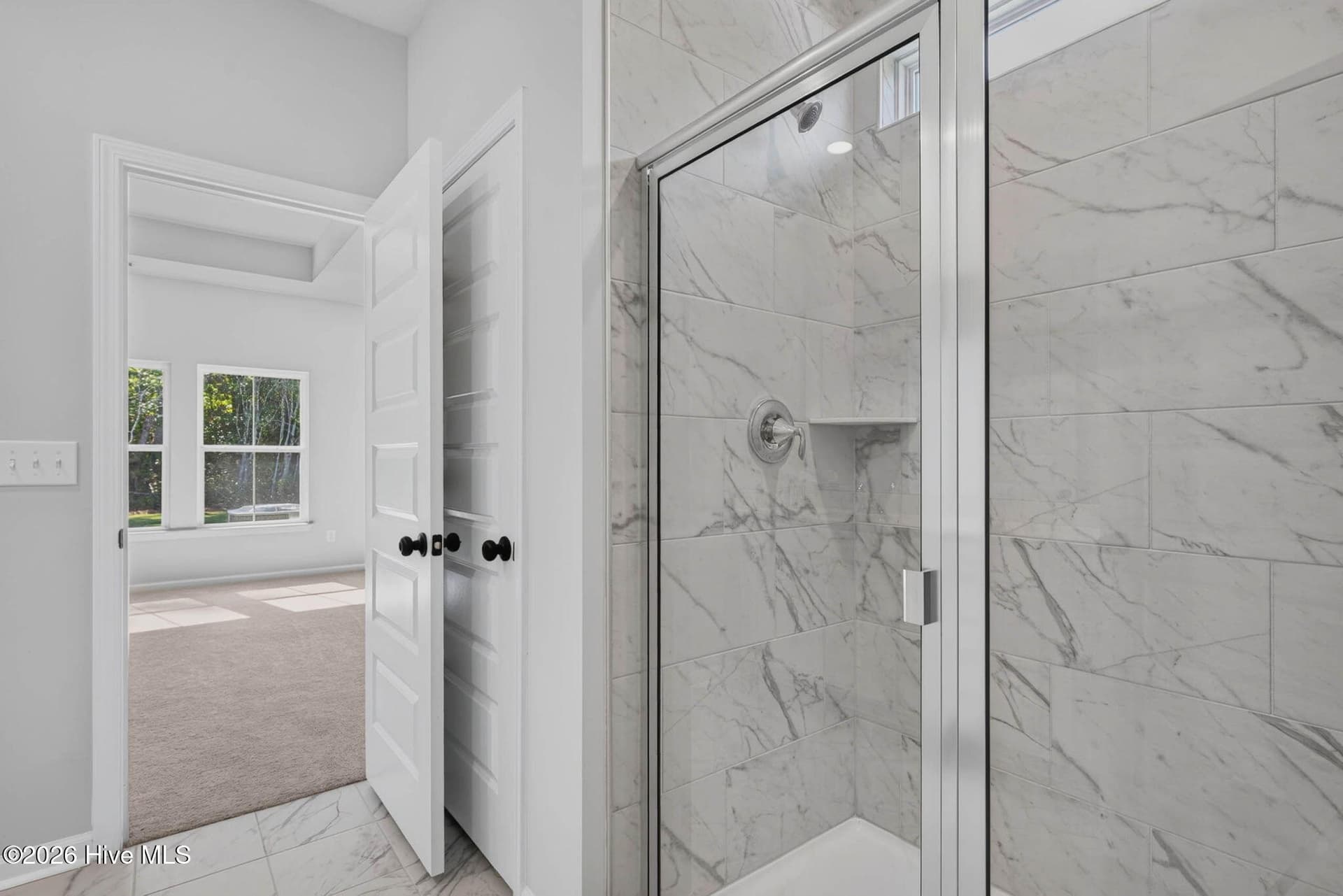 Primary bathroom with a beautifully tiled walk-in shower and glass enclosure. - 3447 Sandhill Crane Drive SW, Ocean Isle Beach, NC 28469