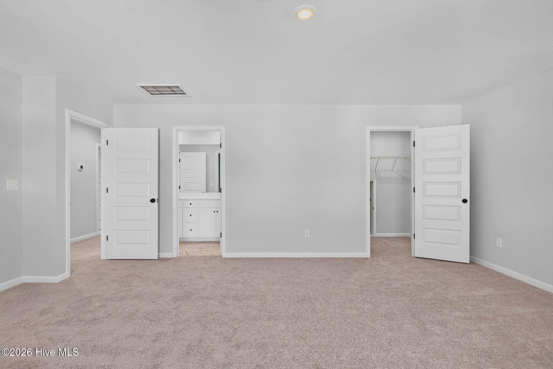 Oversized guest suite featuring plush carpeting, natural light, and multiple closets. - 3447 Sandhill Crane Drive SW, Ocean Isle Beach, NC 28469