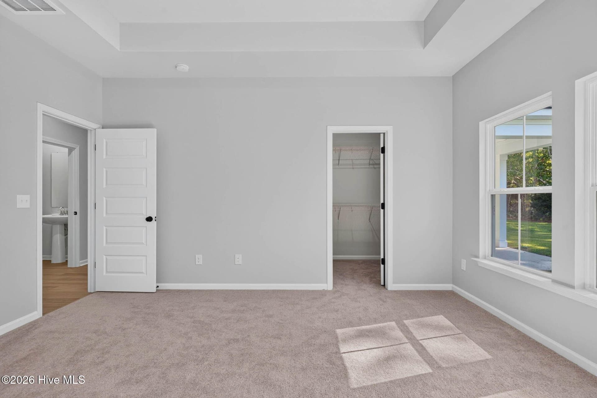 Main-level primary suite entrance with convenient access to the private bedroom and ensuite bathroom. - 3447 Sandhill Crane Drive SW, Ocean Isle Beach, NC 28469