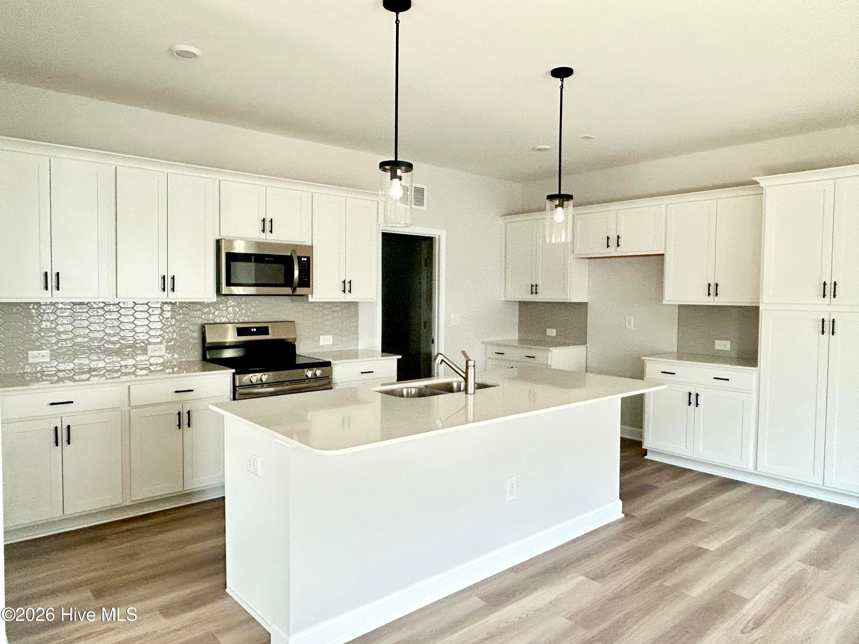 Stunning Kitchen includes Quartz Countertops, Stainless Appliances, Tile Backsplash, Beautiful Lighting fixtures and an abundance of Cabinets. - 4153 Workman Loop 68, Leland, NC 28451