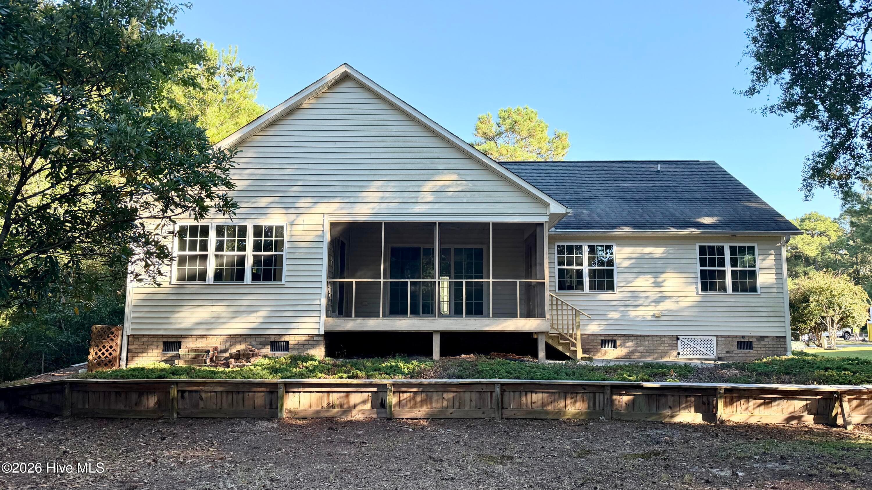 Back yard, raised garden, concrete patio, and screened porch is where your view of the putting green is exceptional! - 1114 Barkentine Drive, New Bern, NC 28560
