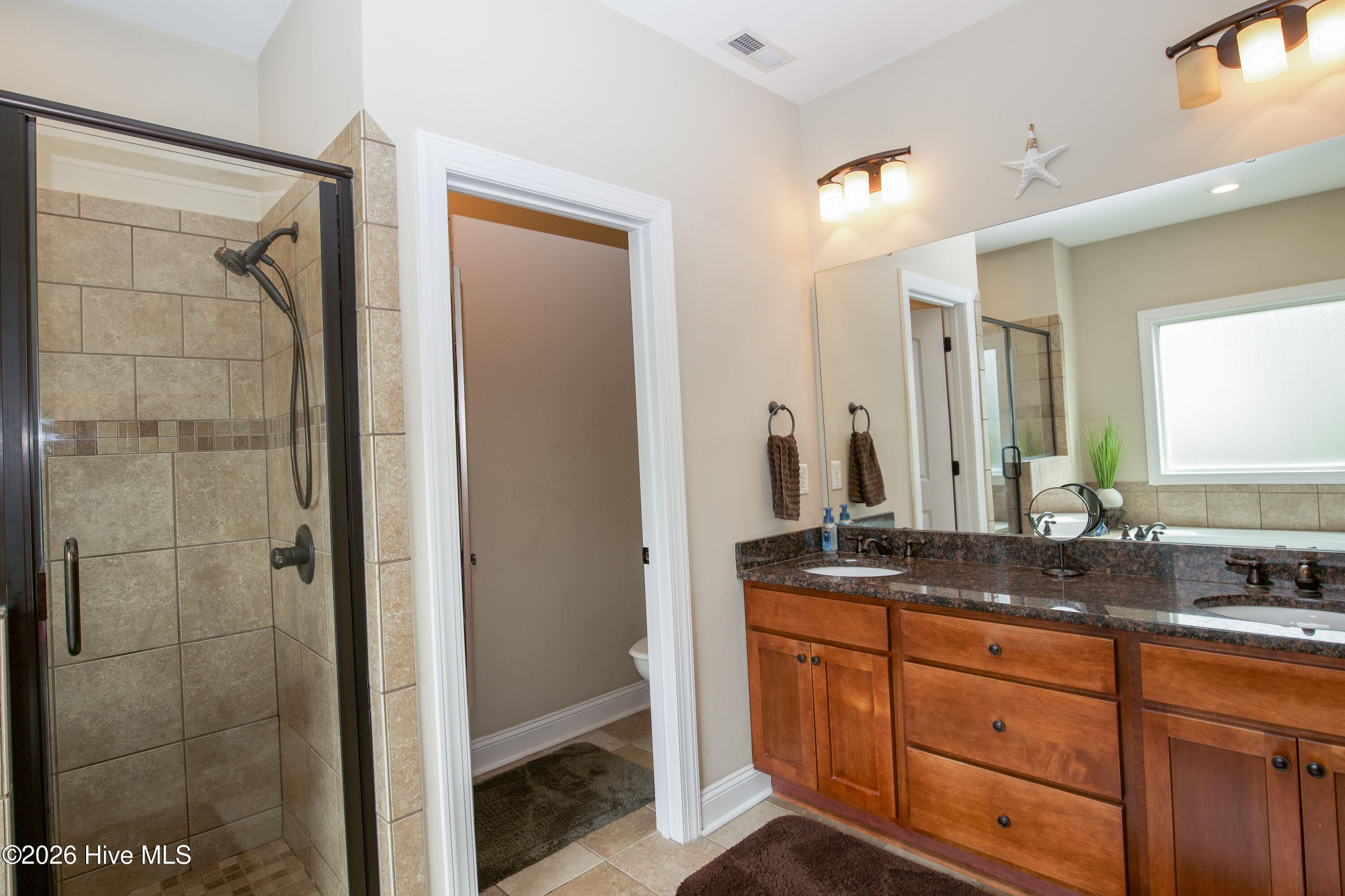 Double vanity with a wide mirror in the primary bath. - 899 Seagull Drive, Vass, NC 28394, Vass
