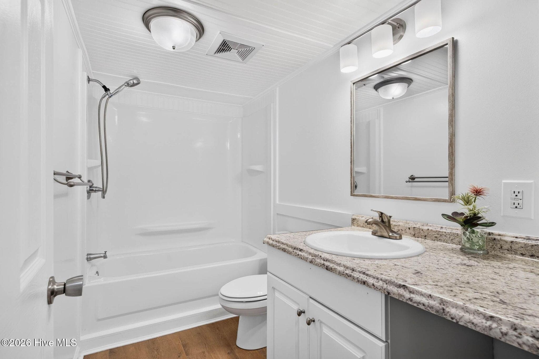 The updated guest bathroom showcases a modern vanity with granite countertops, updated fixtures, and a tub/shower combination designed for everyday convenience. - 1199 Zack Street SE, Bolivia, NC 28422