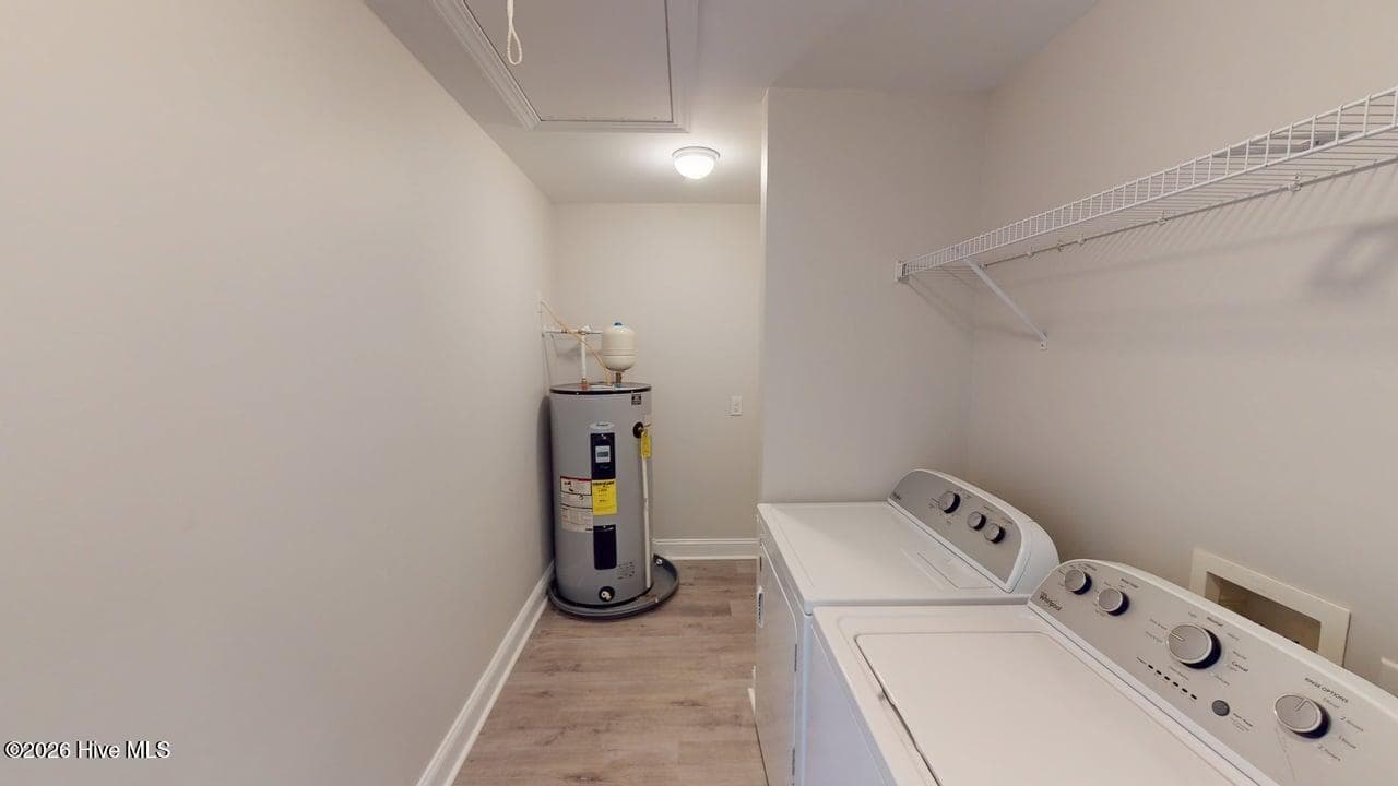 To the right once you enter the front door is the Laundry Room, water heater, and pull down stairs to the partially floored attic. - 1114 Barkentine Drive, New Bern, NC 28560