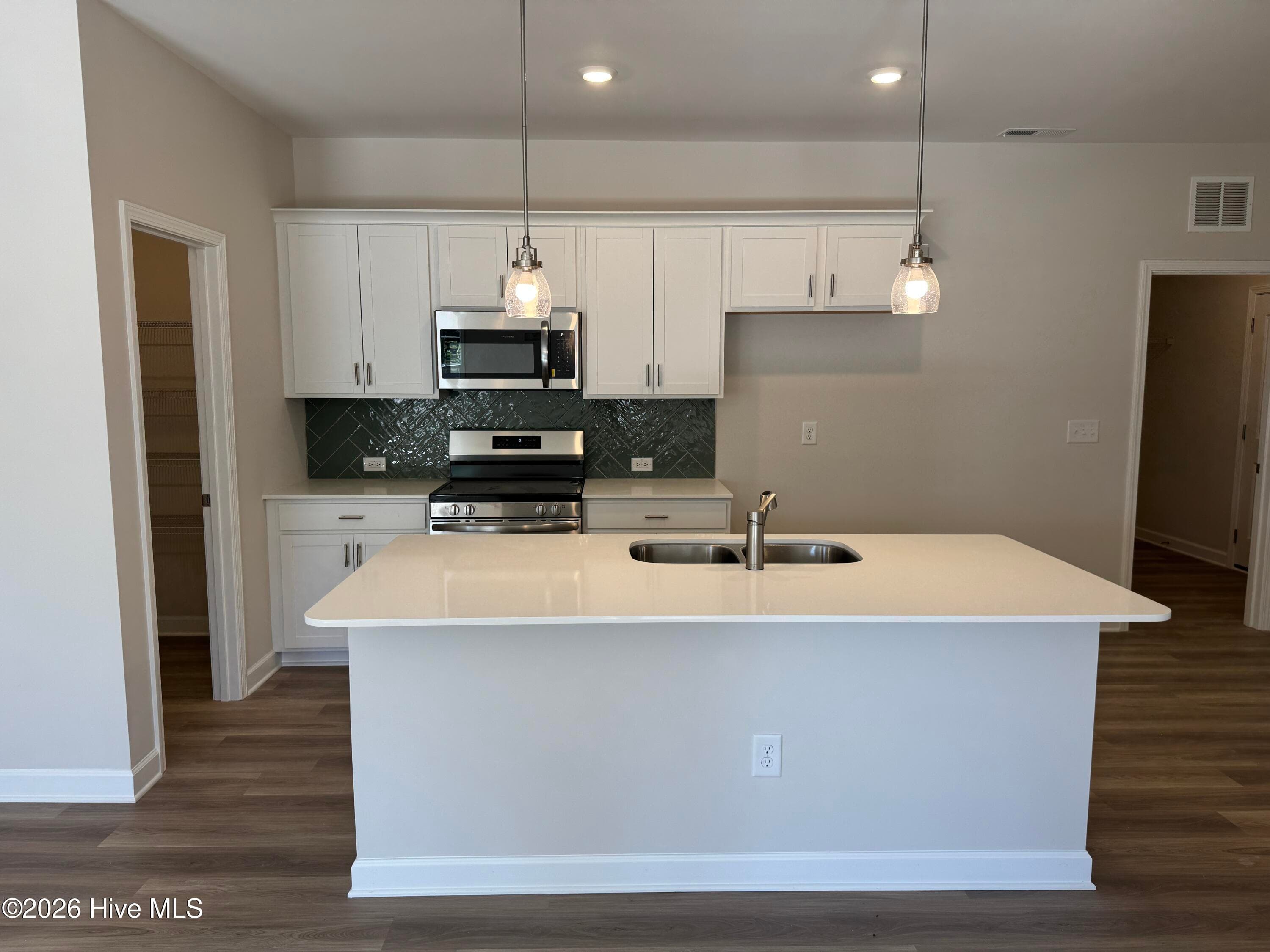 Elegant Kitchen includes Deluxe Pantry, Quartz Countertops, Stainless Appliances, Tile Backsplash, and Beautiful Lighting fixtures. - 4145 Workman Loop 66, Leland, NC 28451