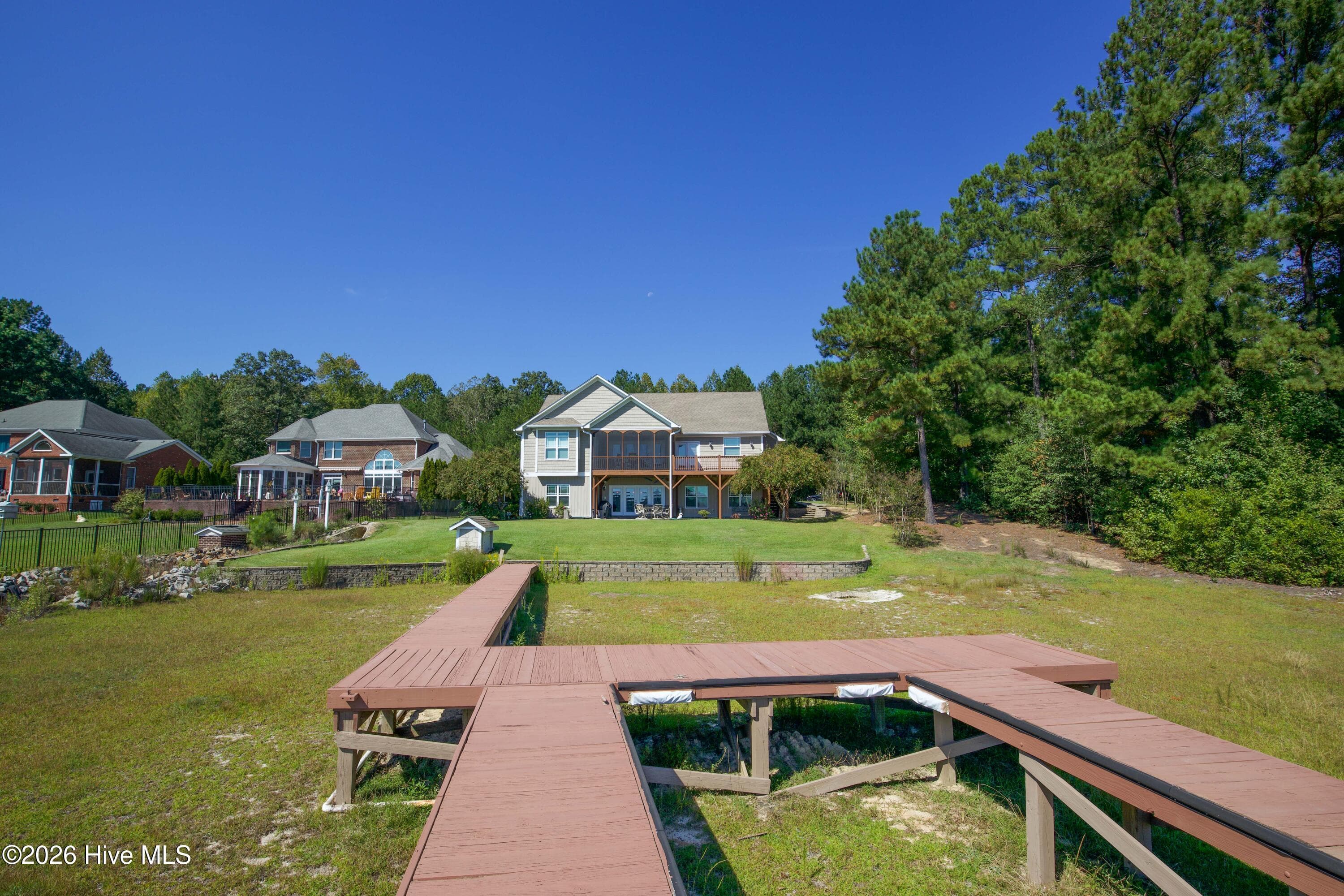 Looking back from the dock to the screened porch, deck, and lower patio. - 899 Seagull Drive, Vass, NC 28394, Vass