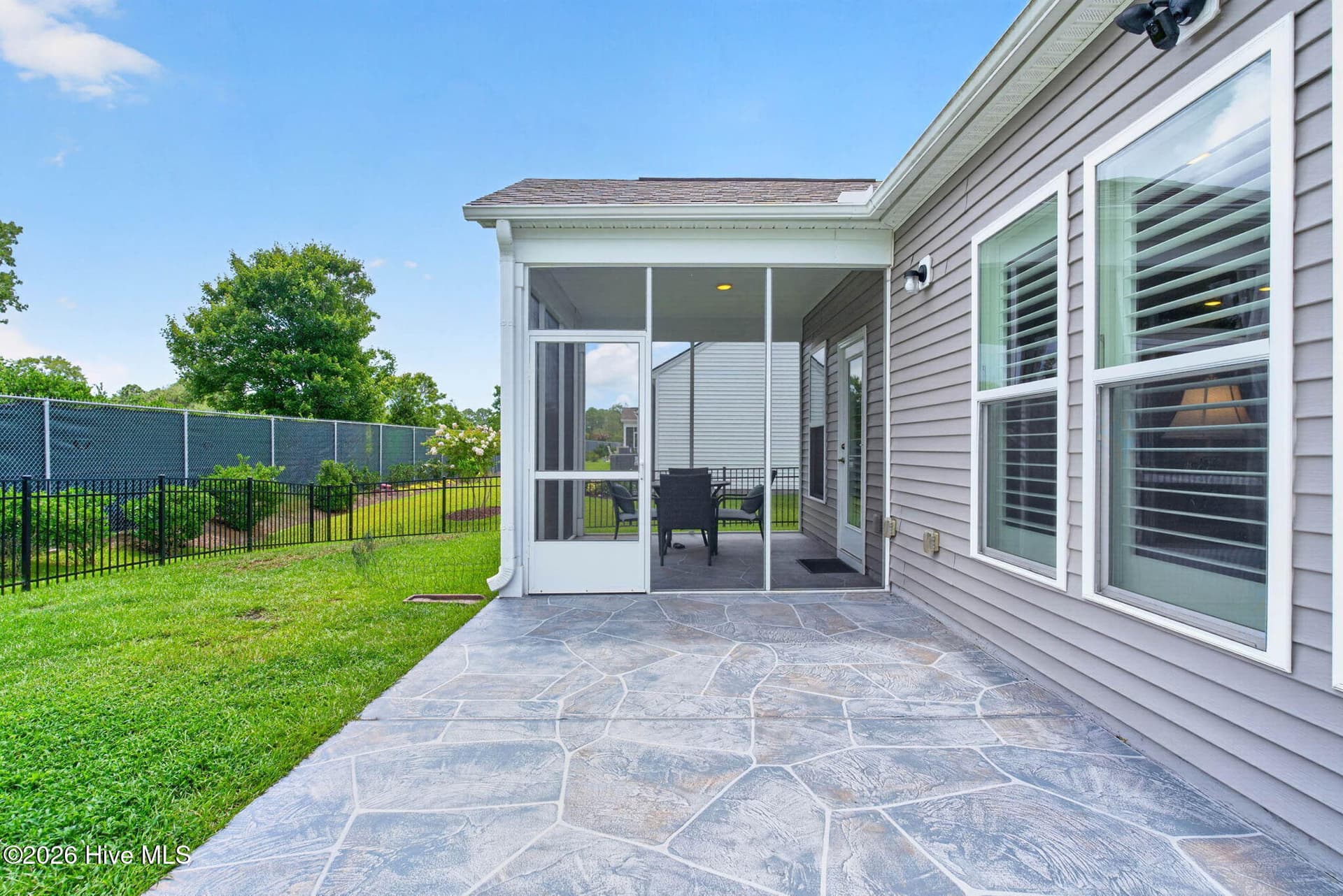 A patio and screened porch create multiple options for outdoor dining, entertaining, and relaxing in the Carolina sunshine. - 139 Eagle Claw Drive, Calabash, NC 28467