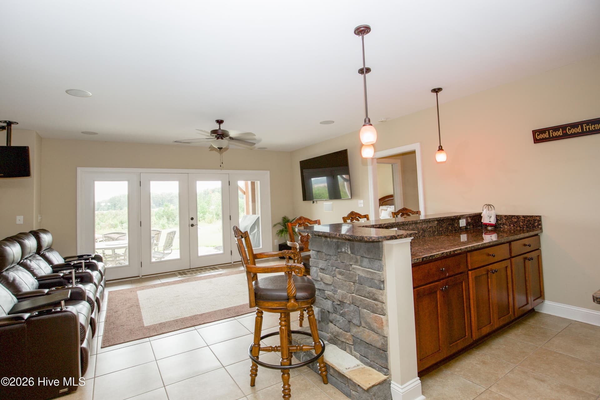 Stone-front wet bar with seating, next to the media area. - 899 Seagull Drive, Vass, NC 28394