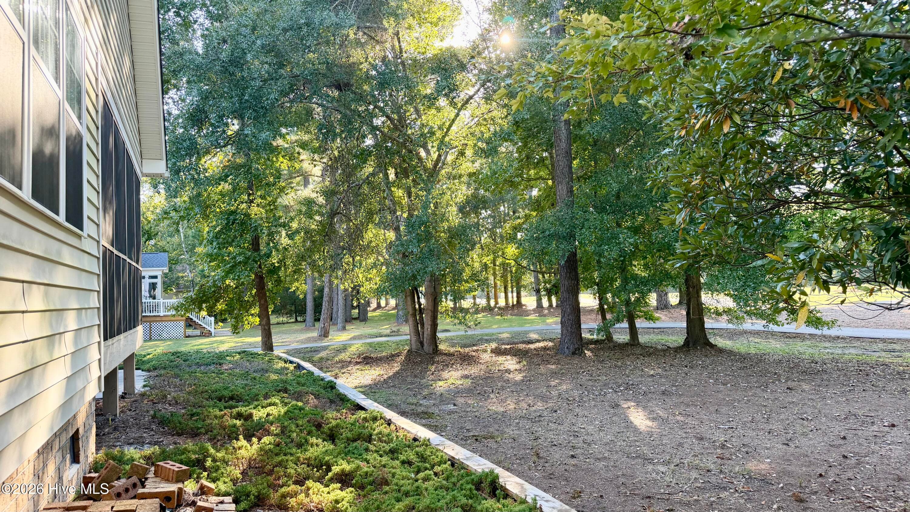 View from the N corner of the home overlooking the raised garden, backyard, and through the trees the fairway! - 1114 Barkentine Drive, New Bern, NC 28560