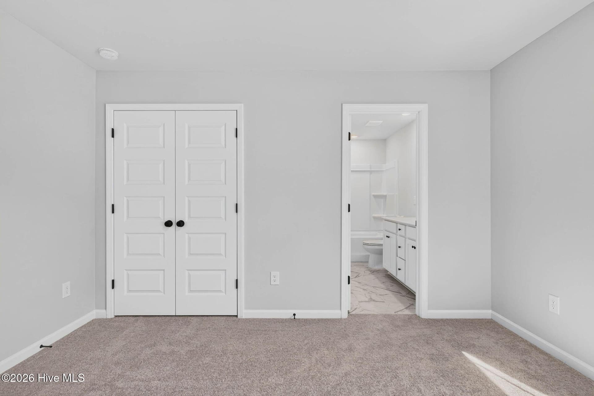 Secondary bedroom featuring a spacious layout and convenient access to an upstairs bathroom. - 3447 Sandhill Crane Drive SW, Ocean Isle Beach, NC 28469