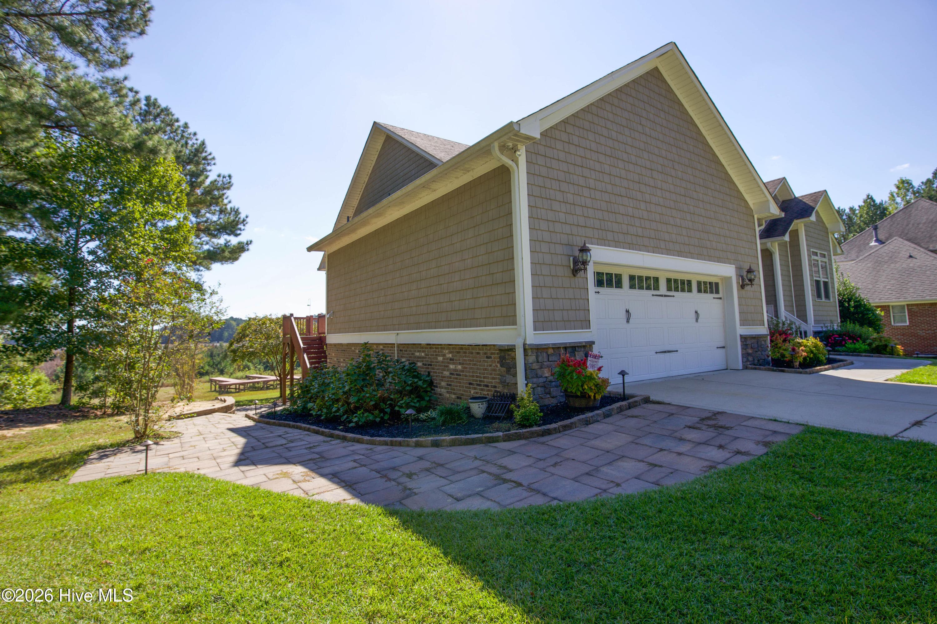 Side of the home and driveway at 899 Seagull Drive in Woodlake, Vass NC, with the deck corner at the rear. - 899 Seagull Drive, Vass, NC 28394, Vass