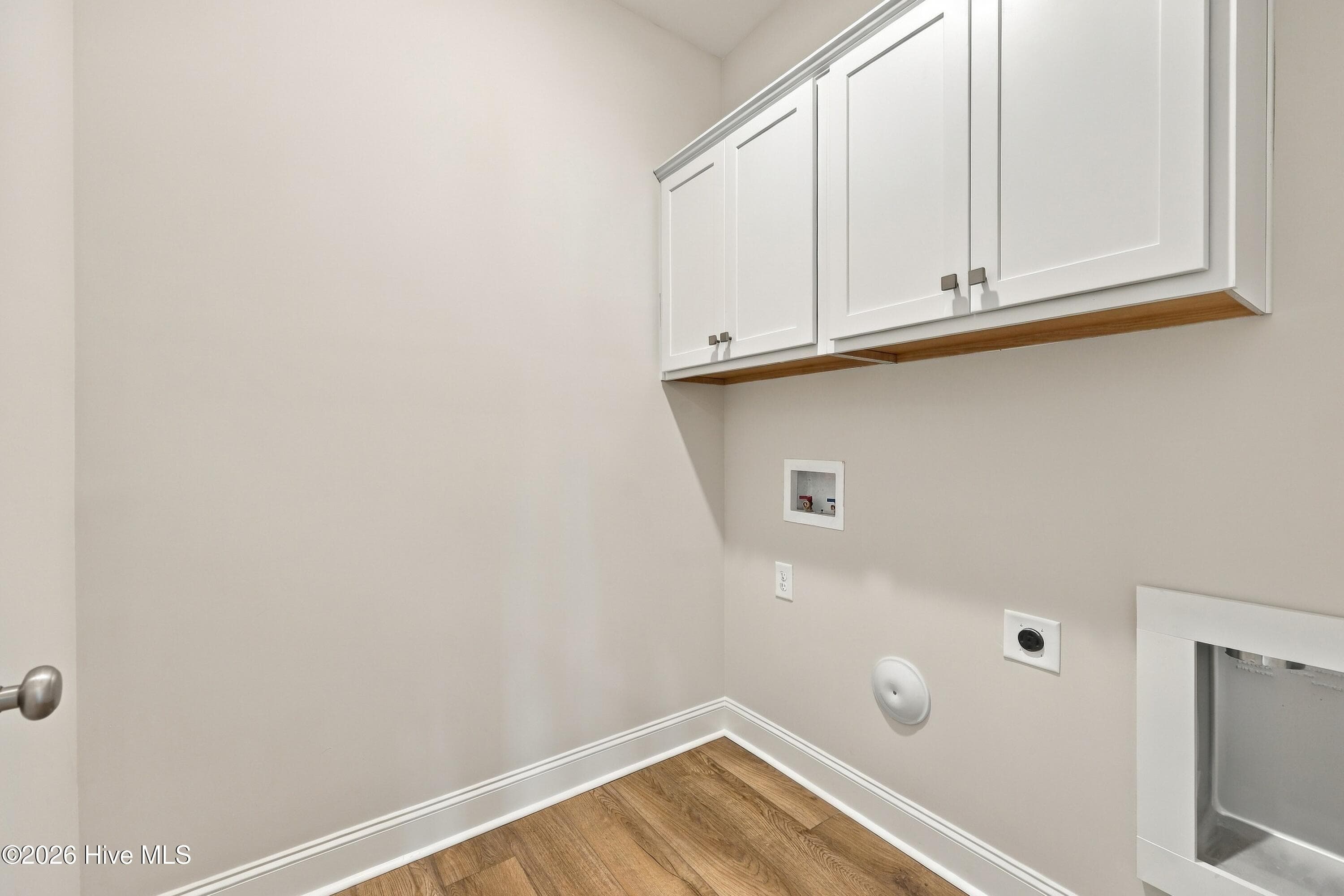 this laundry room sits down a hall with storage cabinets - 3229 Meadow Drive, Farmville, NC 27828
