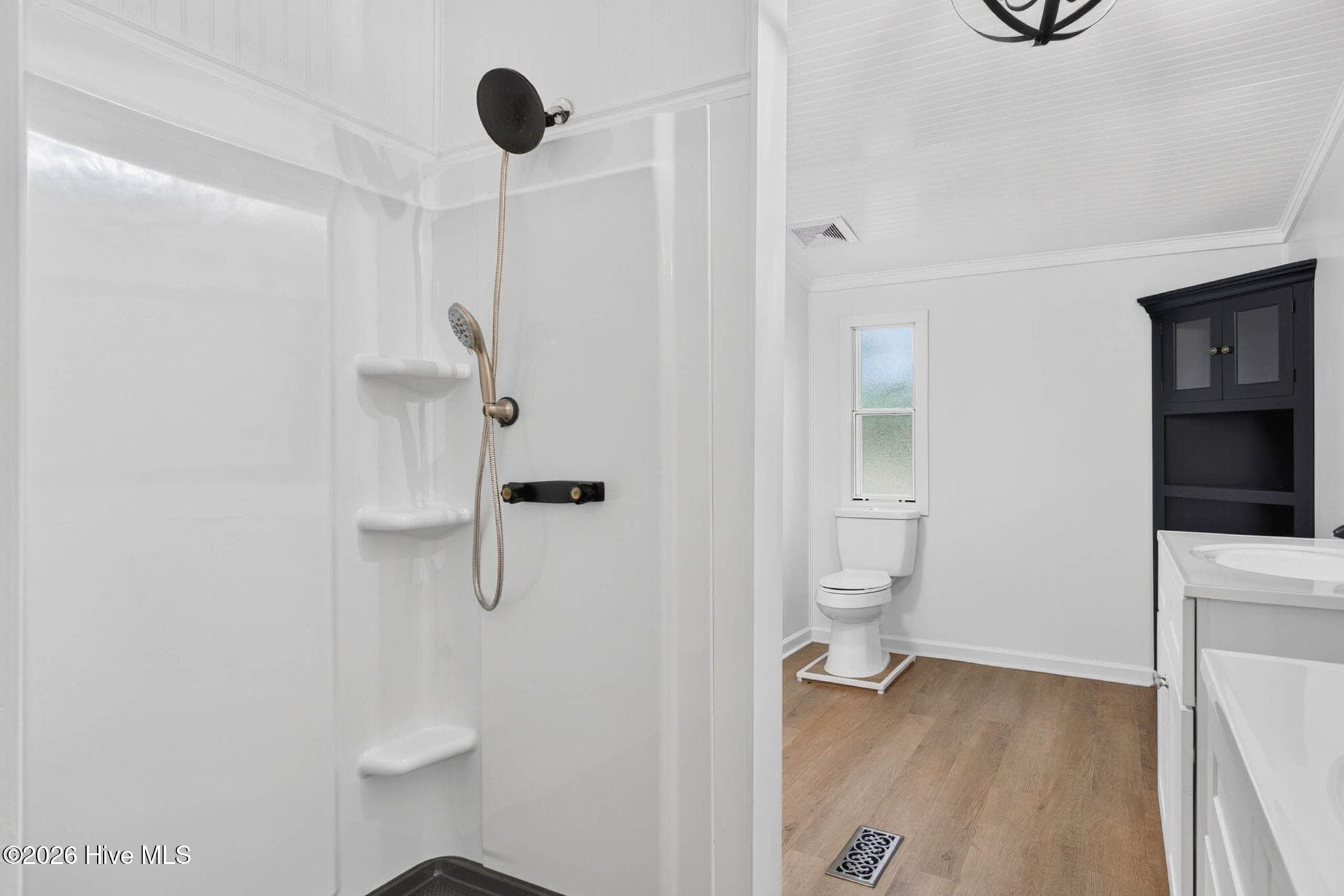 The renovated walk-in shower showcases contemporary finishes and a clean, modern design for a spa-like experience. - 1199 Zack Street SE, Bolivia, NC 28422