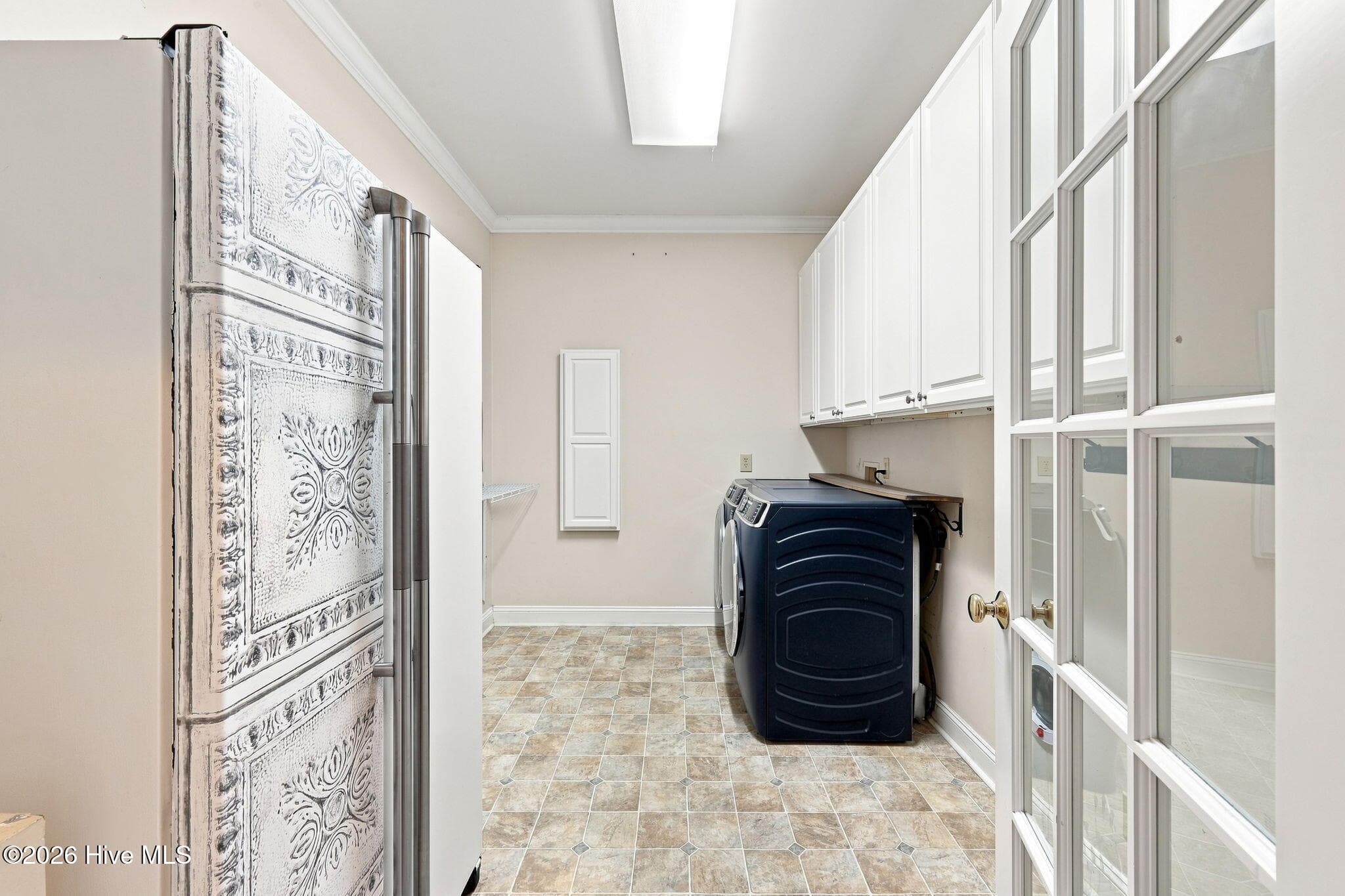 Laundry area and mudroom with refrigerator and built-in ironing board - 407 Rustic Court, Pollocksville, NC 28573