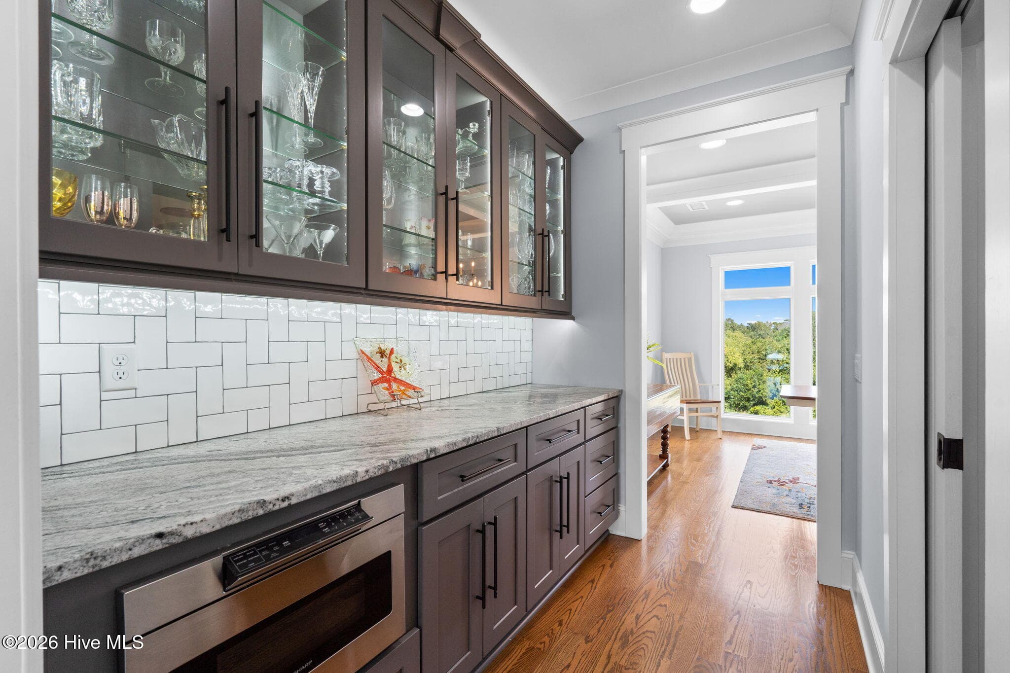 Glass, lighted cabinetry plus above and below counter lighting really shows off this space. Undercounter microwave too. Huge walk-in food pantry on right - 2775 Long Bay Drive SE, Southport, NC 28461