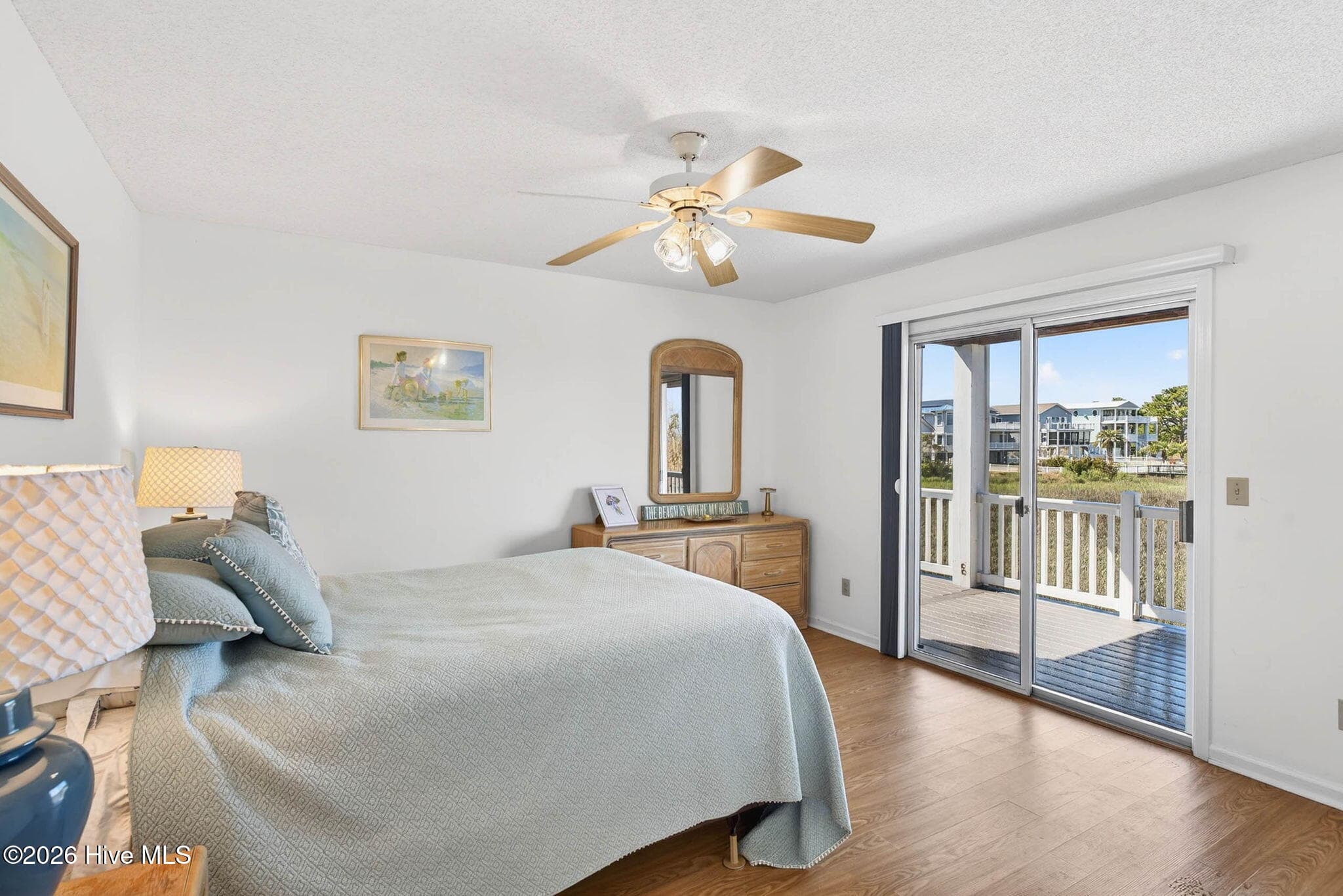 Bedroom with sliding glass doors leading to outdoor deck and water views. - 1206 N Shore Drive W, Sunset Beach, NC 28468, Sunset Beach