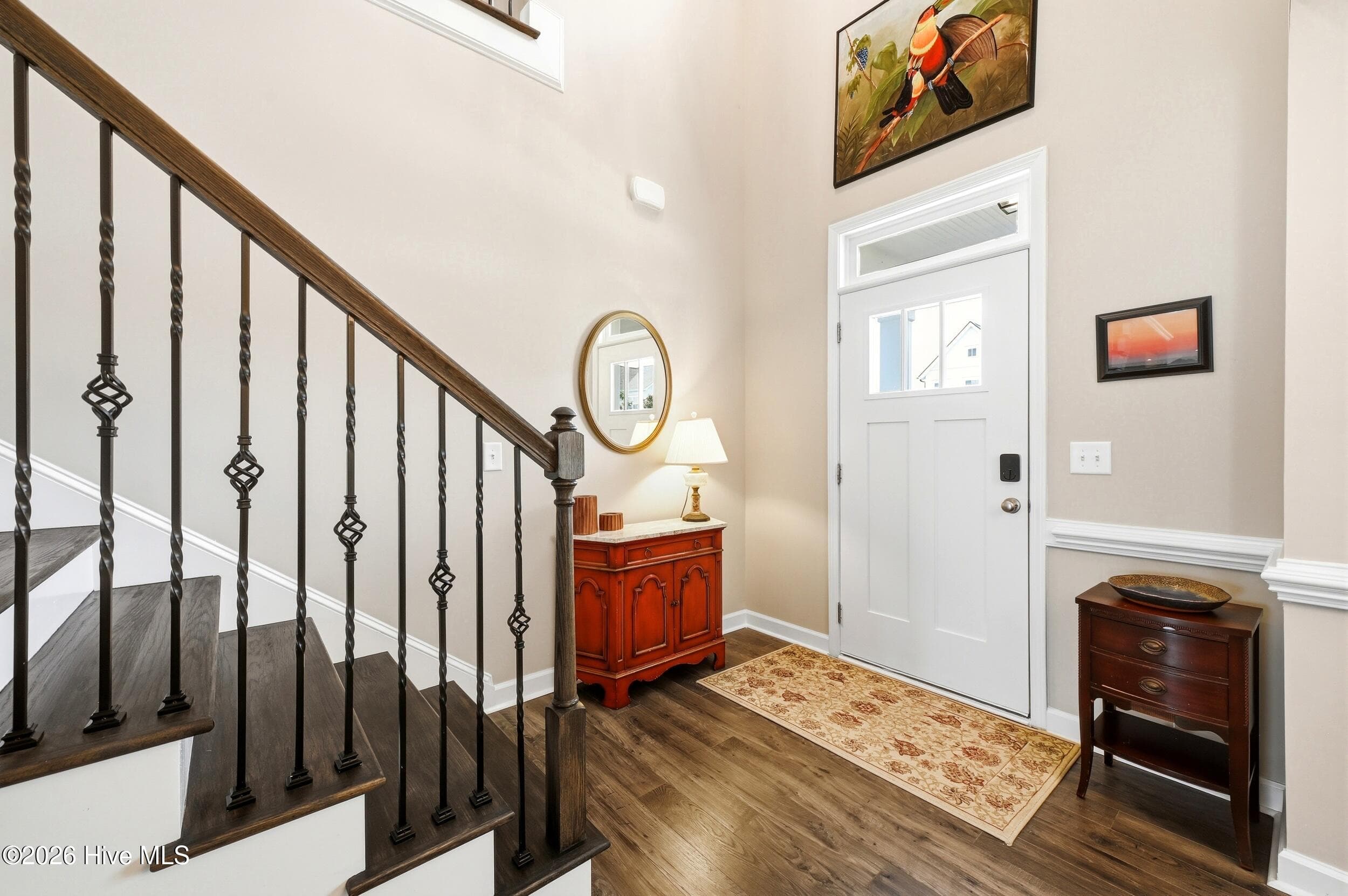 Two story entrance hall Premium Laminate flooring and wood steps. The black metal balusters continue all the way to the top of the steps and into the loft. - 220 Trawlers Way, Wilmington, NC 28412