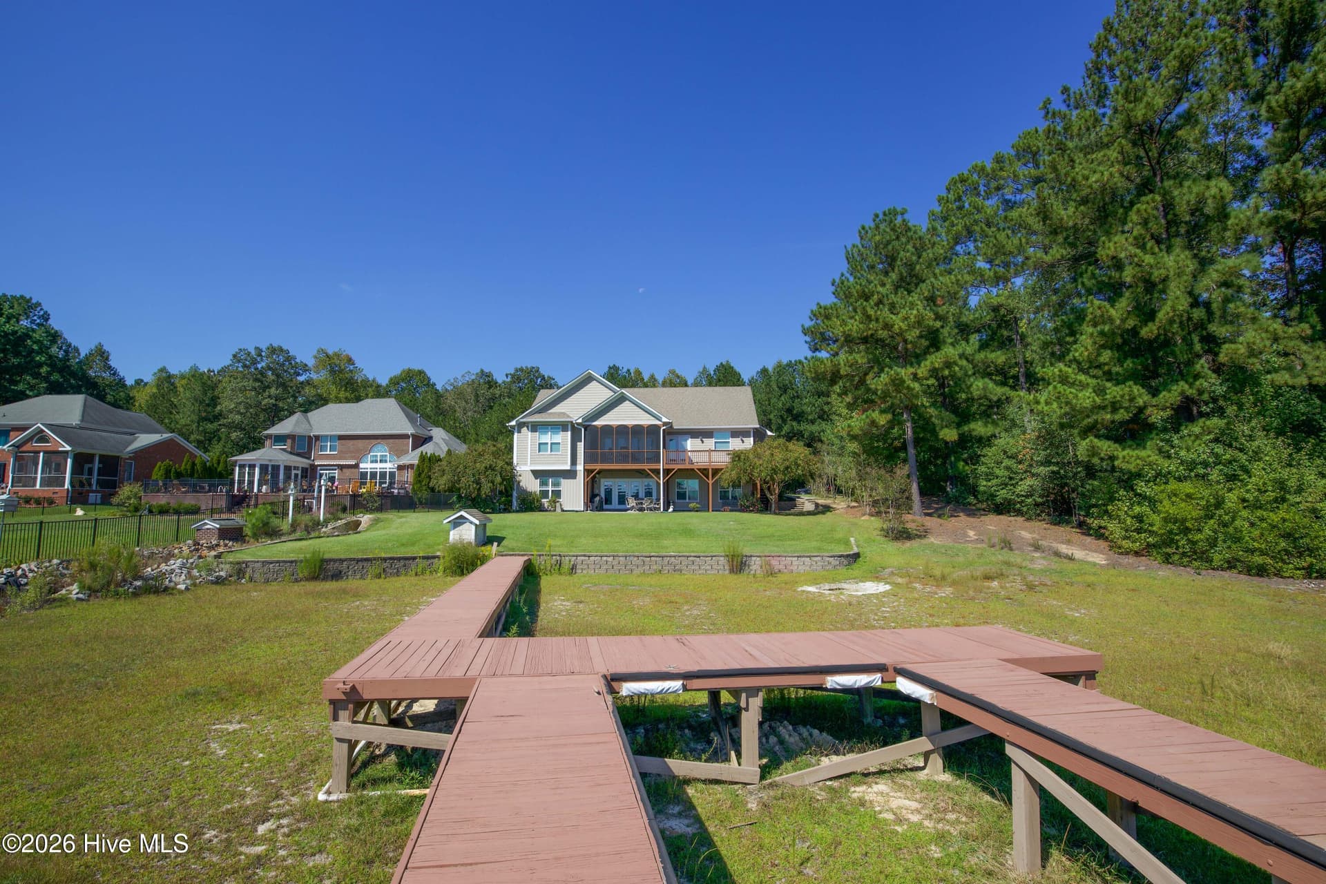 Looking back from the dock to the lakefront side of 899 Seagull Drive, with the screened porch and deck above the lower patio, Woodlake, Vass NC. - 899 Seagull Drive, Vass, NC 28394