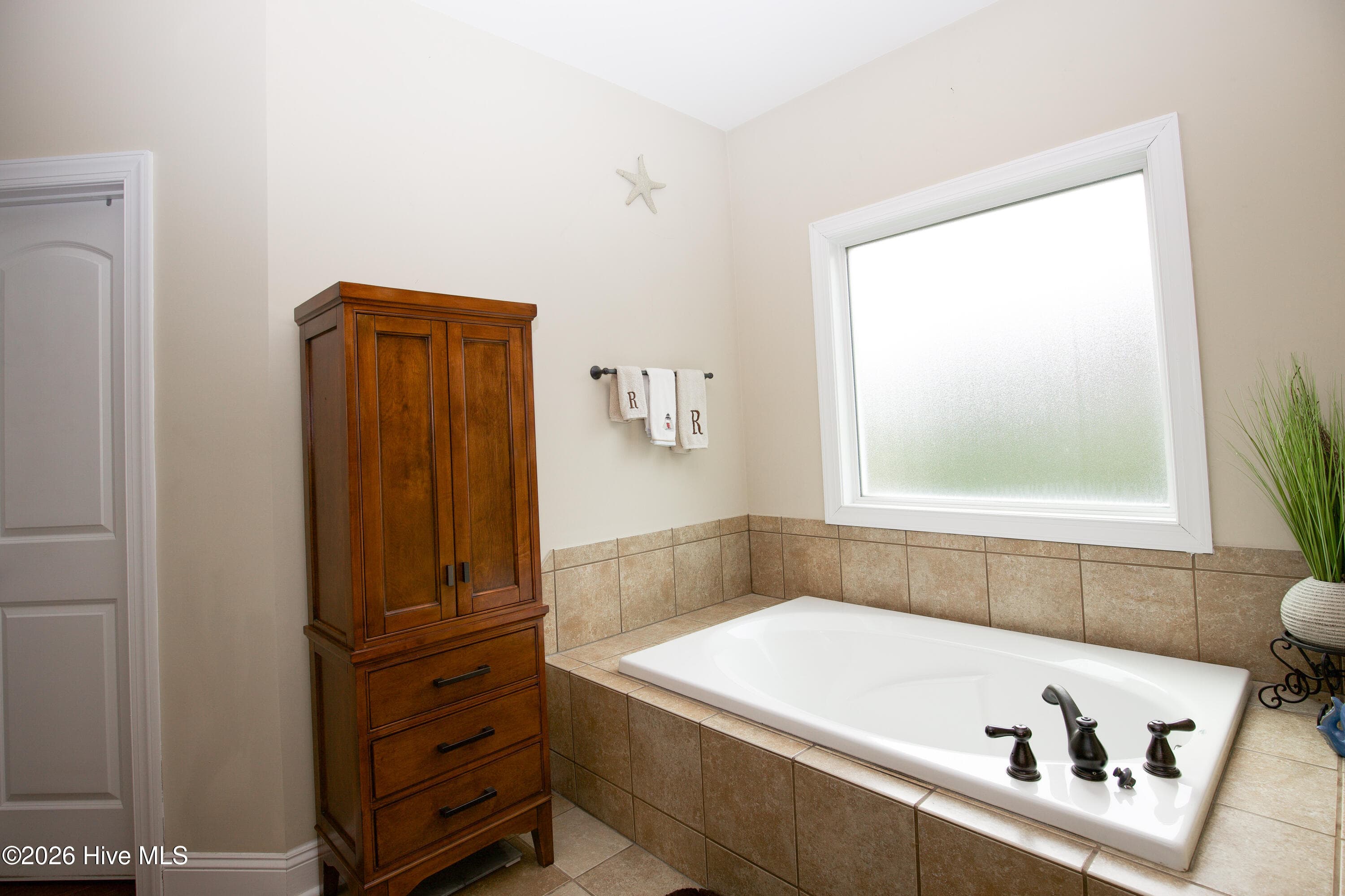 Primary bath tub beneath a privacy window. - 899 Seagull Drive, Vass, NC 28394, Vass