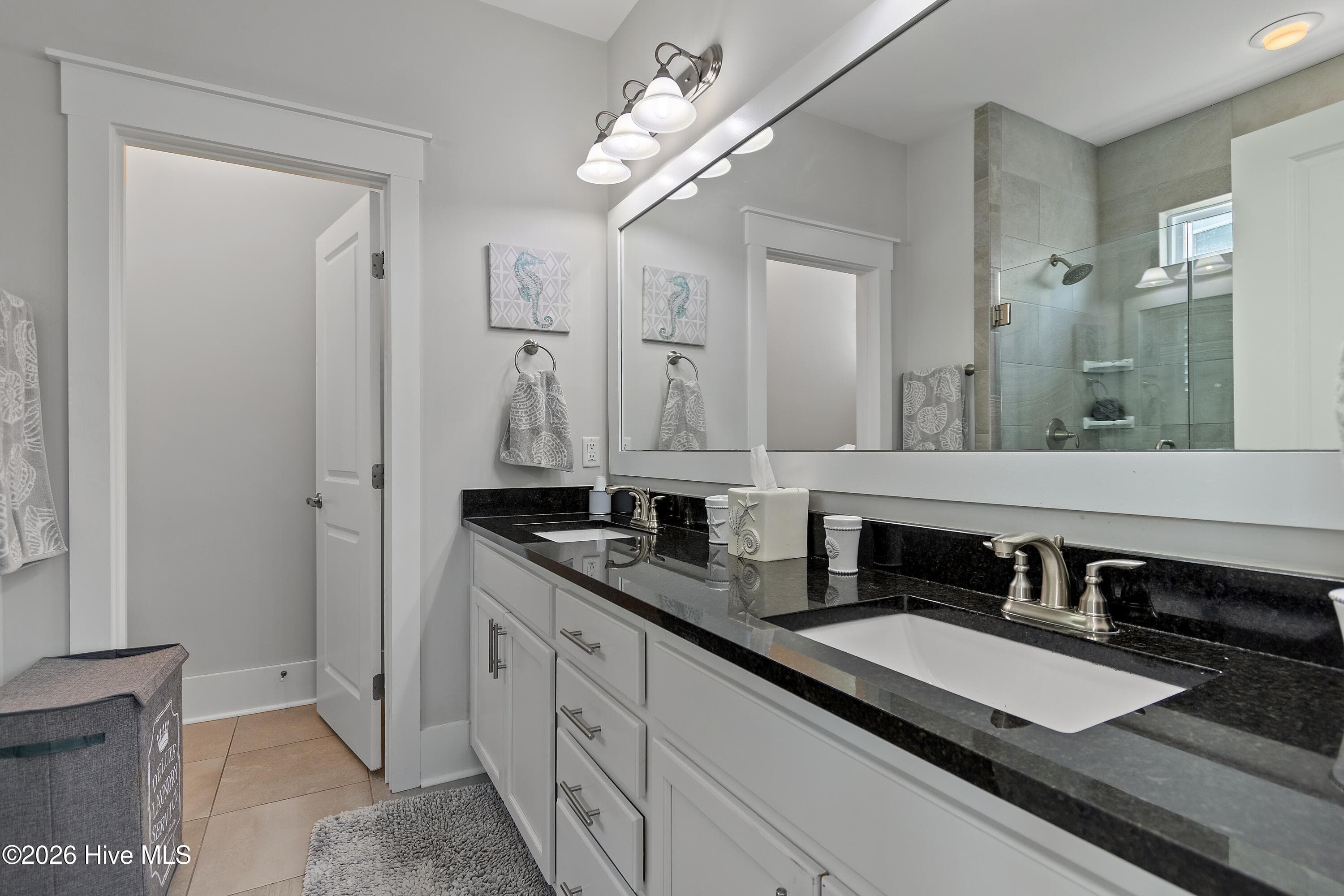 Primary bathroom with dual vanities and water closet for privacy. - 6358 Bryson Drive SW, Ocean Isle Beach, NC 28469