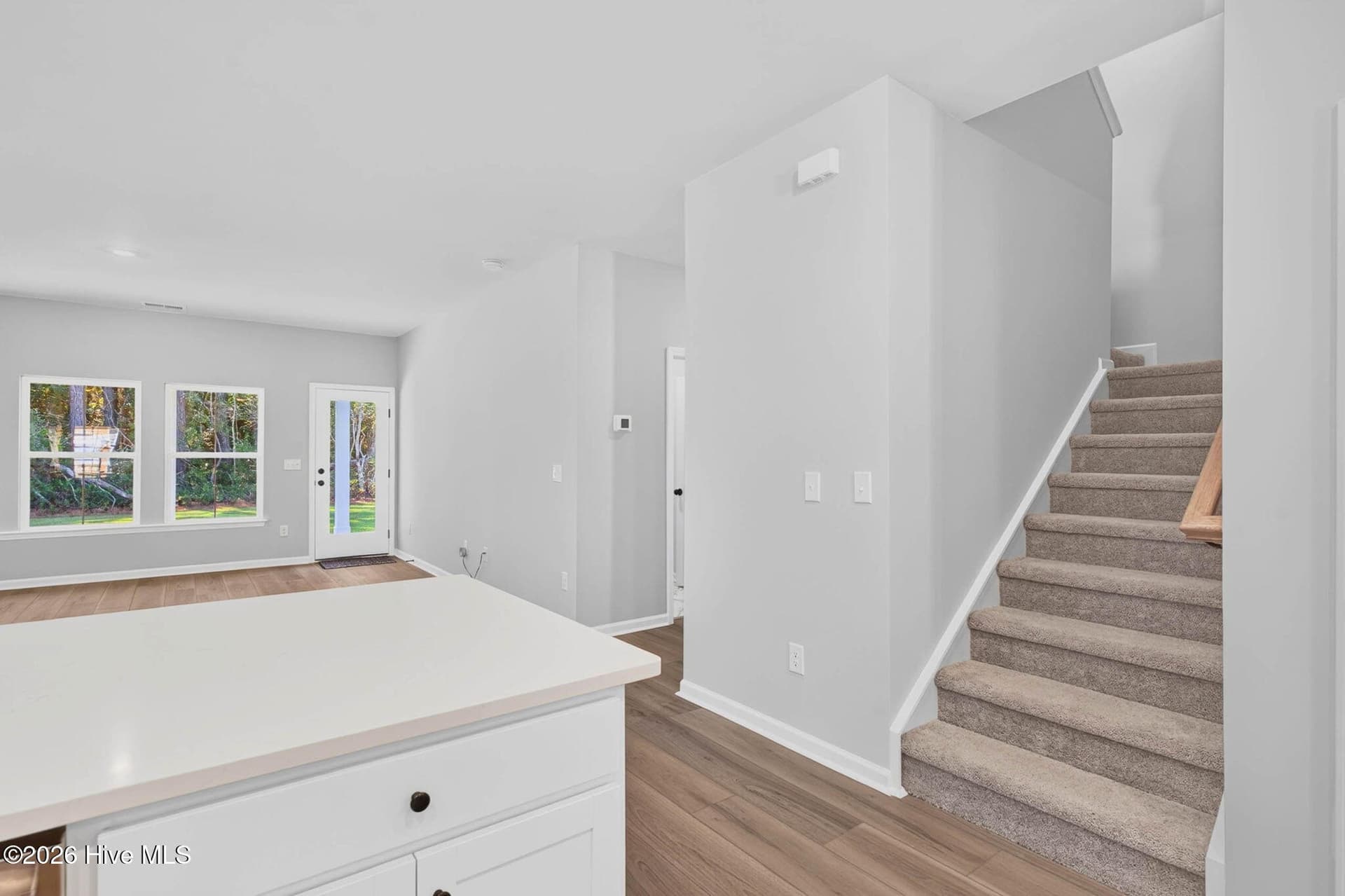 Open-concept main living area with staircase leading to four additional upstairs bedrooms. - 3447 Sandhill Crane Drive SW, Ocean Isle Beach, NC 28469
