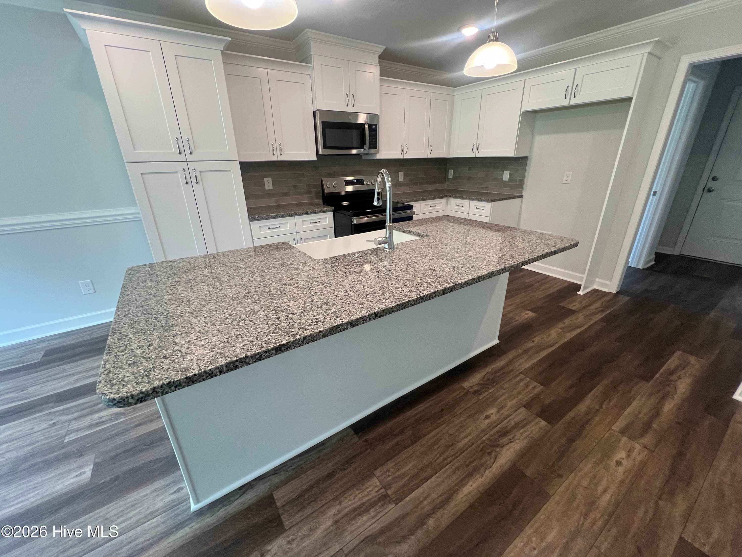 Large island overlooking the great room with a farm house sink. - 8887 Snelling Drive, Aiken, SC 29803