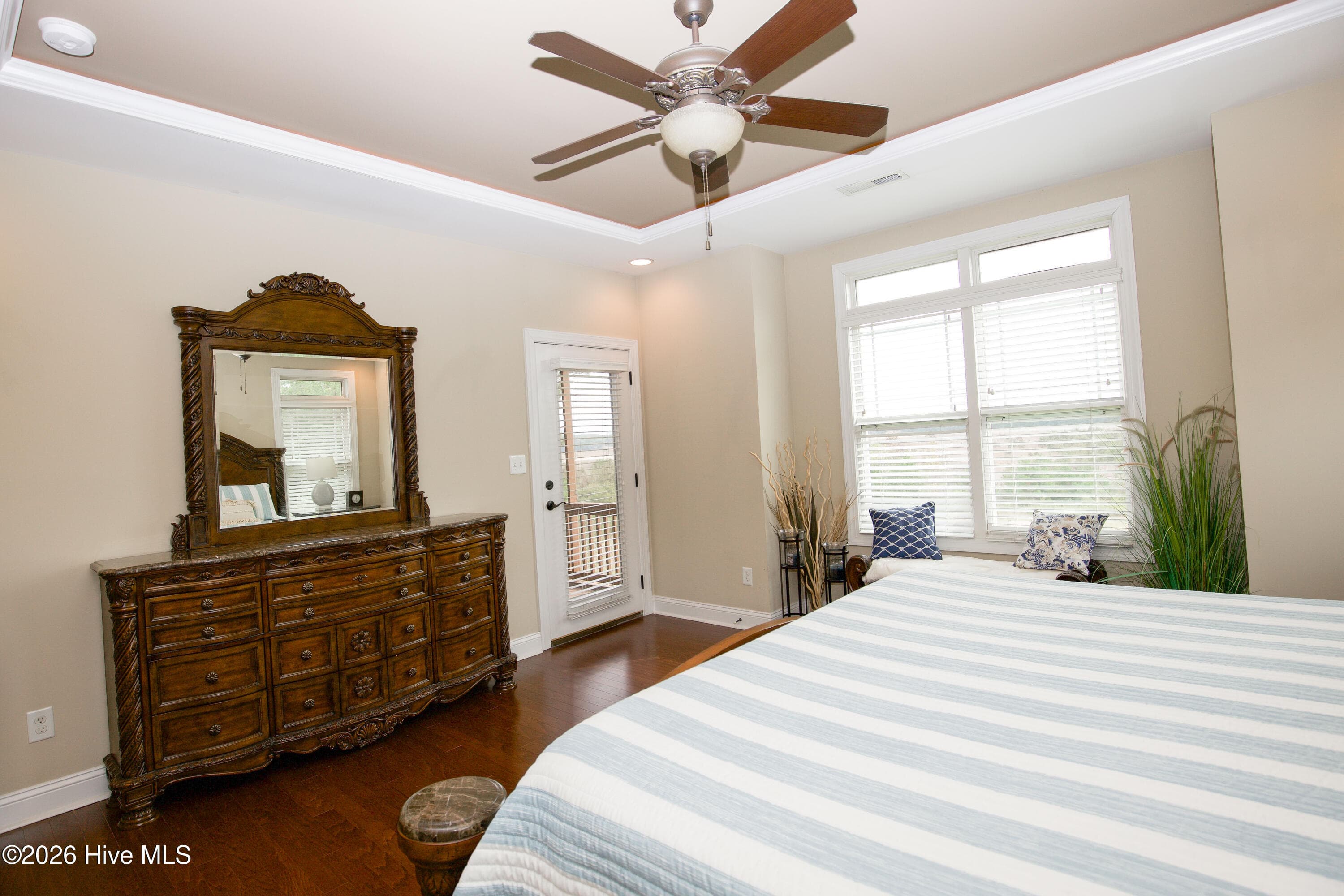 Primary bedroom with a tray ceiling, ceiling fan and a door to the screened porch. - 899 Seagull Drive, Vass, NC 28394, Vass
