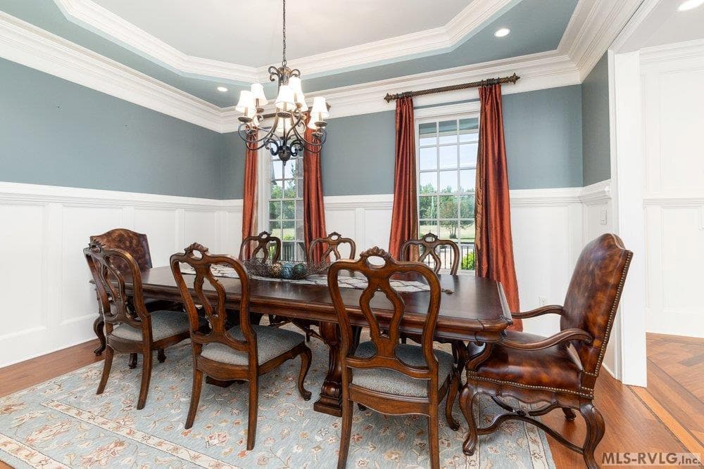 Dining Room, Host unforgettable gatherings in the sophisticated formal dining room, where timeless architecture meets refined style. Classic wainscoting and detailed crown molding create a layered, high-end design - 381 West Bend Dr., Gasburg VA 23857, Gasburg