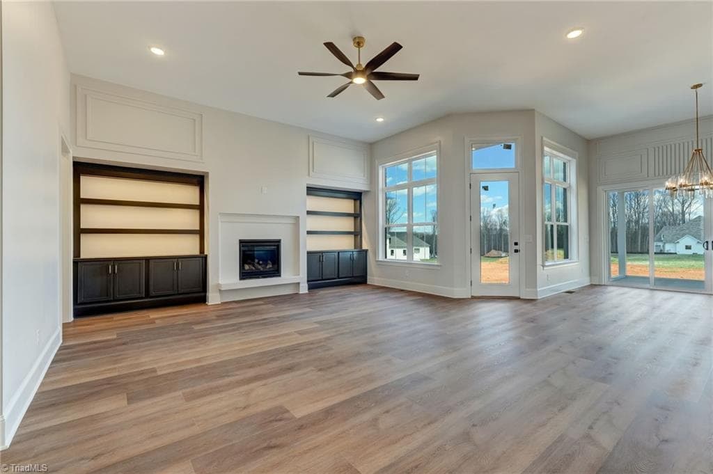 Great room features gas fireplace with floating hearth flanked by custom built ins with accent lighting - 7688 Kyran Court, Oak Ridge NC 27310, Oak Ridge