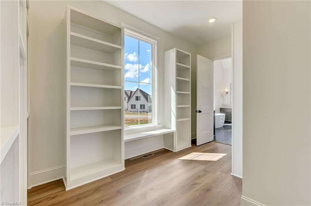 Primary walk-in closet is a dream with a custom closet organization system - 7688 Kyran Court, Oak Ridge NC 27310, Oak Ridge