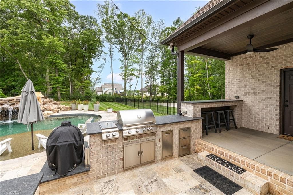 Outdoor kitchen with grill. Covered porch and bar. Includes a 1/2 bath. - 5503 Briardenn Court, Summerfield NC 27358, Summerfield